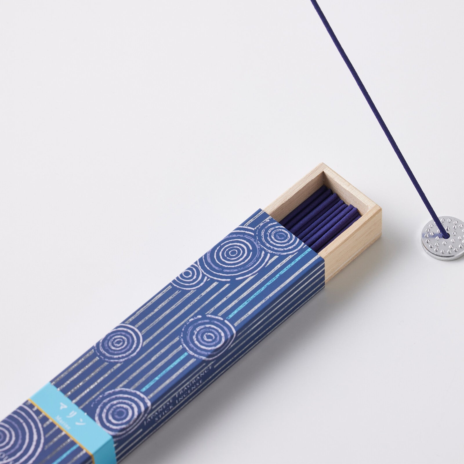 Hyakuranko Marine Incense Stick in elegant blue packaging with circular wave patterns, emitting a fresh marine aroma ideal for home fragrance.