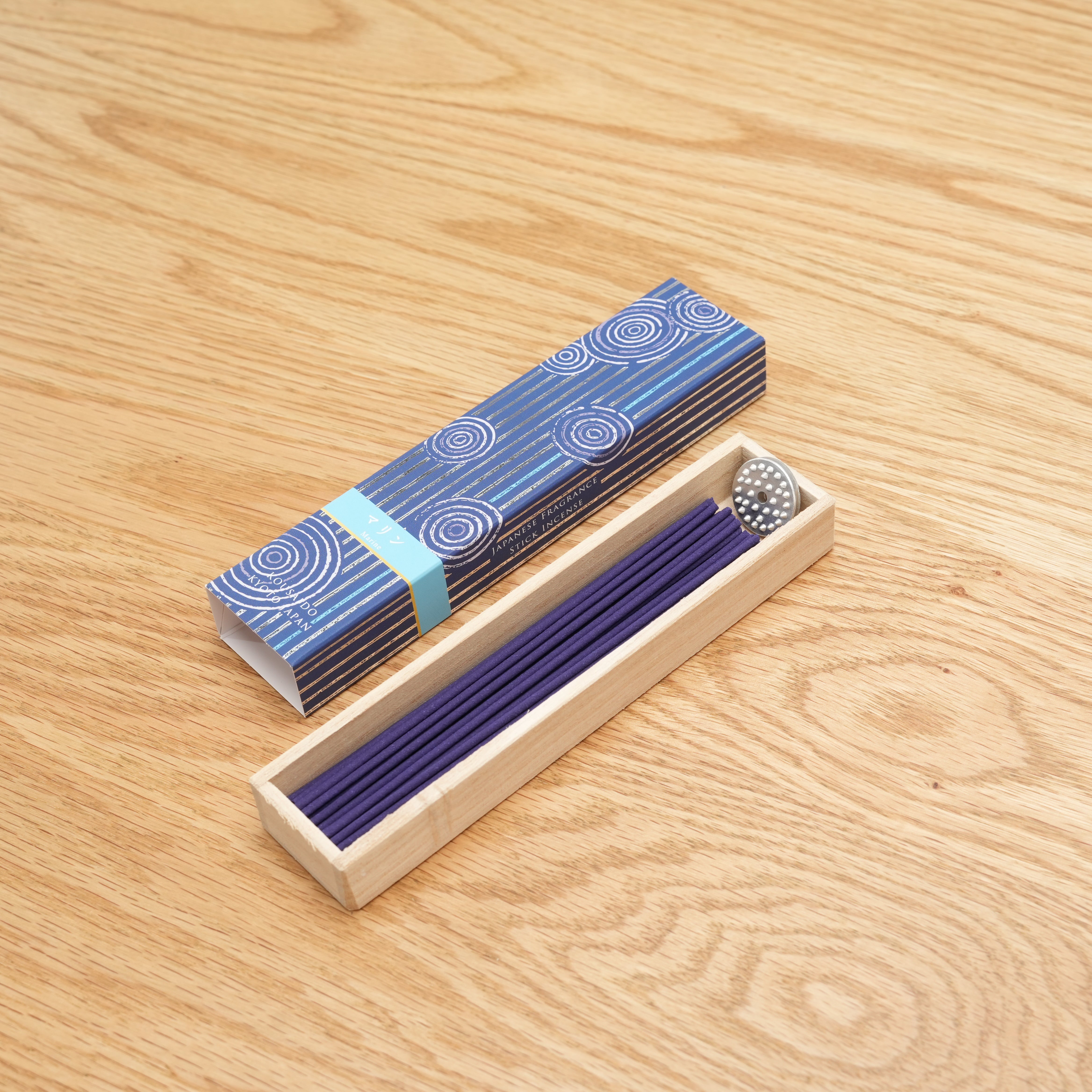 Hyakuranko Marine Incense Stick in a wooden tray with blue packaging featuring wave patterns, ideal for home fragrance and decor use.