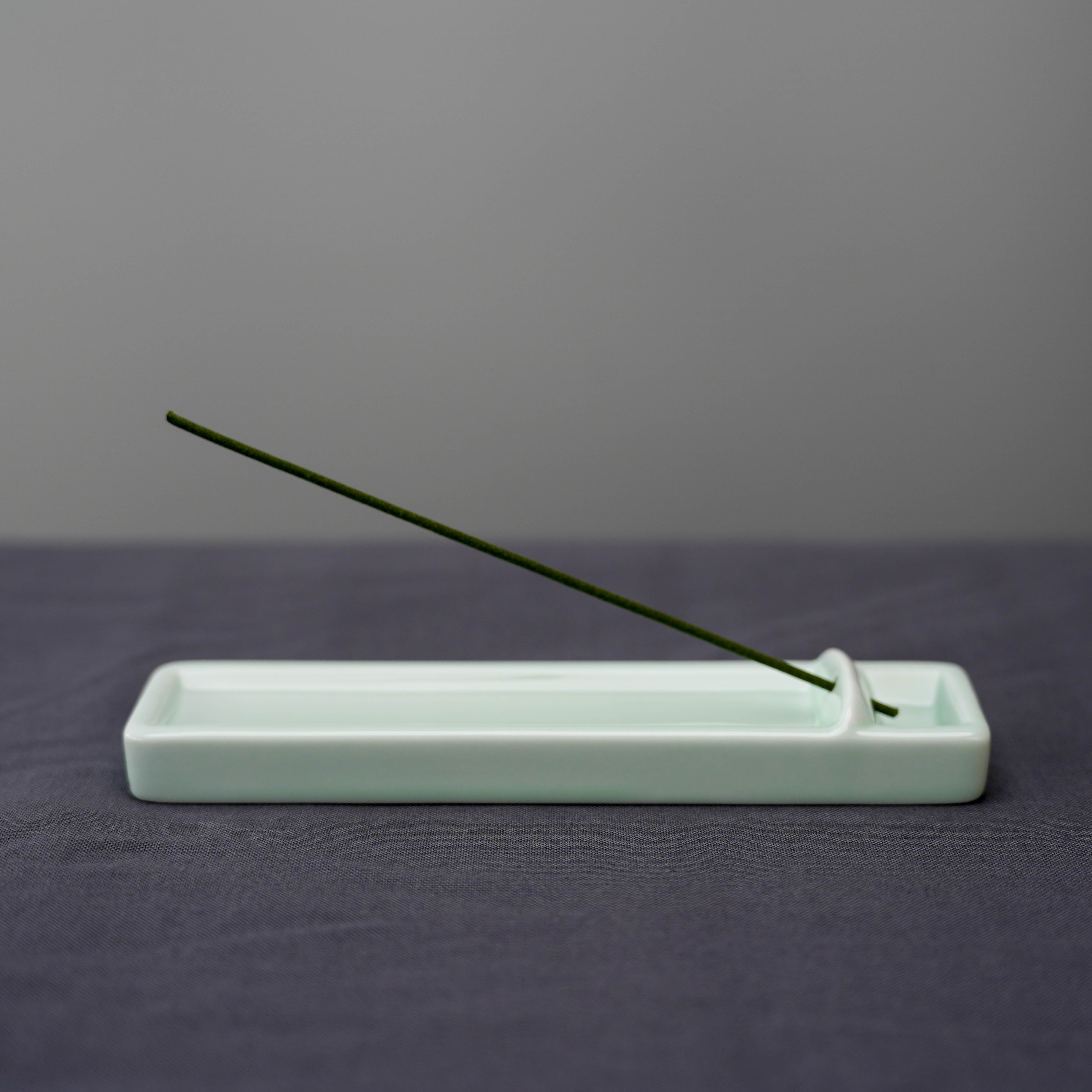 Kosaido Long Incense Holder in use with incense stick, showcasing its sleek Japanese design for clean ash collection and aroma diffusion.