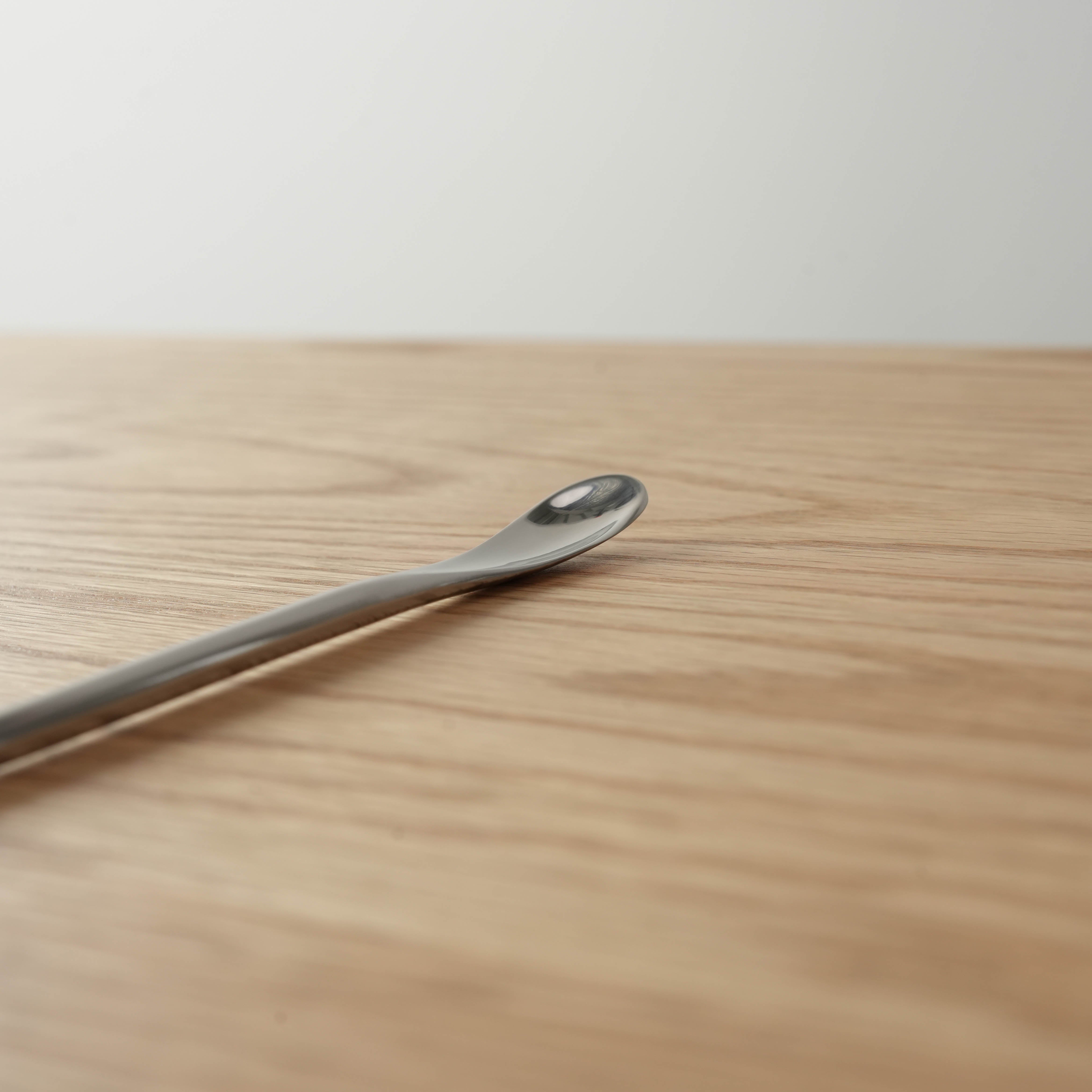 Close-up of Sori Yanagi Stainless Steel Drink Stirrer showing its ergonomic spoon tip and polished finish, perfect for precise mixing tasks.