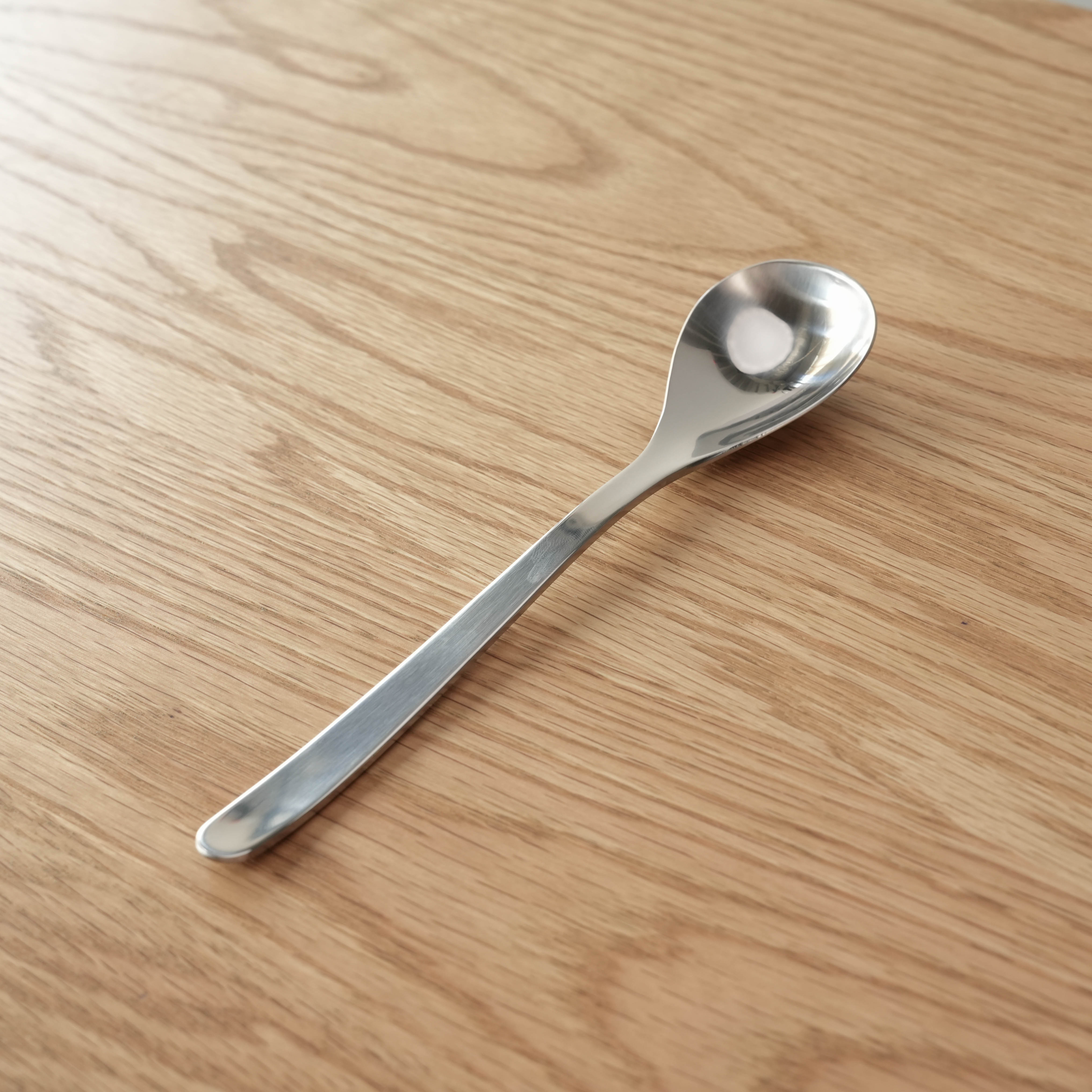 Sori Yanagi Stainless Steel Table Spoon with seamless design on wooden surface. 183mm length, 42g weight, ideal for everyday dining use.