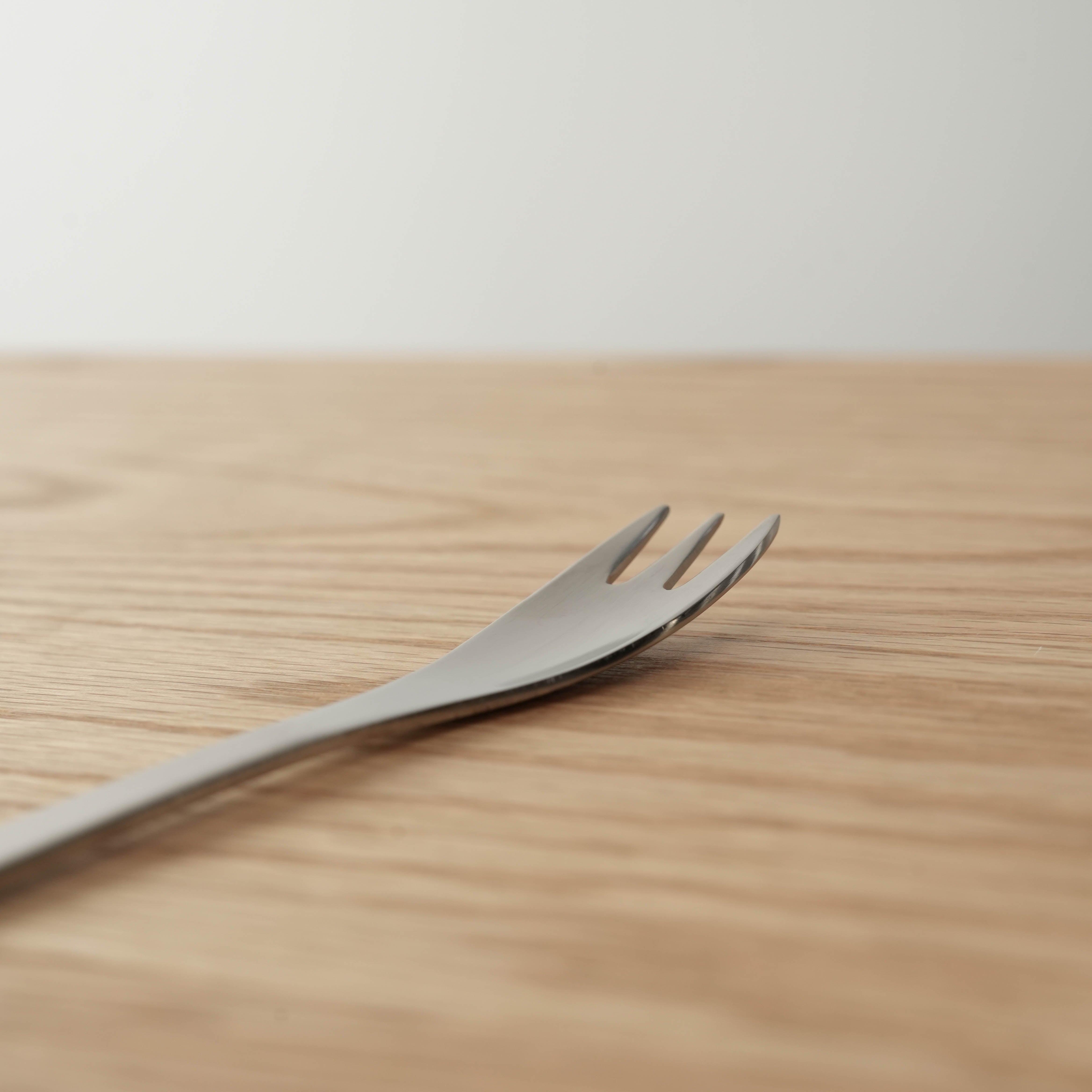 Close-up of Sori Yanagi Stainless Steel Cake Fork showing angled tines and ergonomic curve. Perfect for layered pastries and cakes.