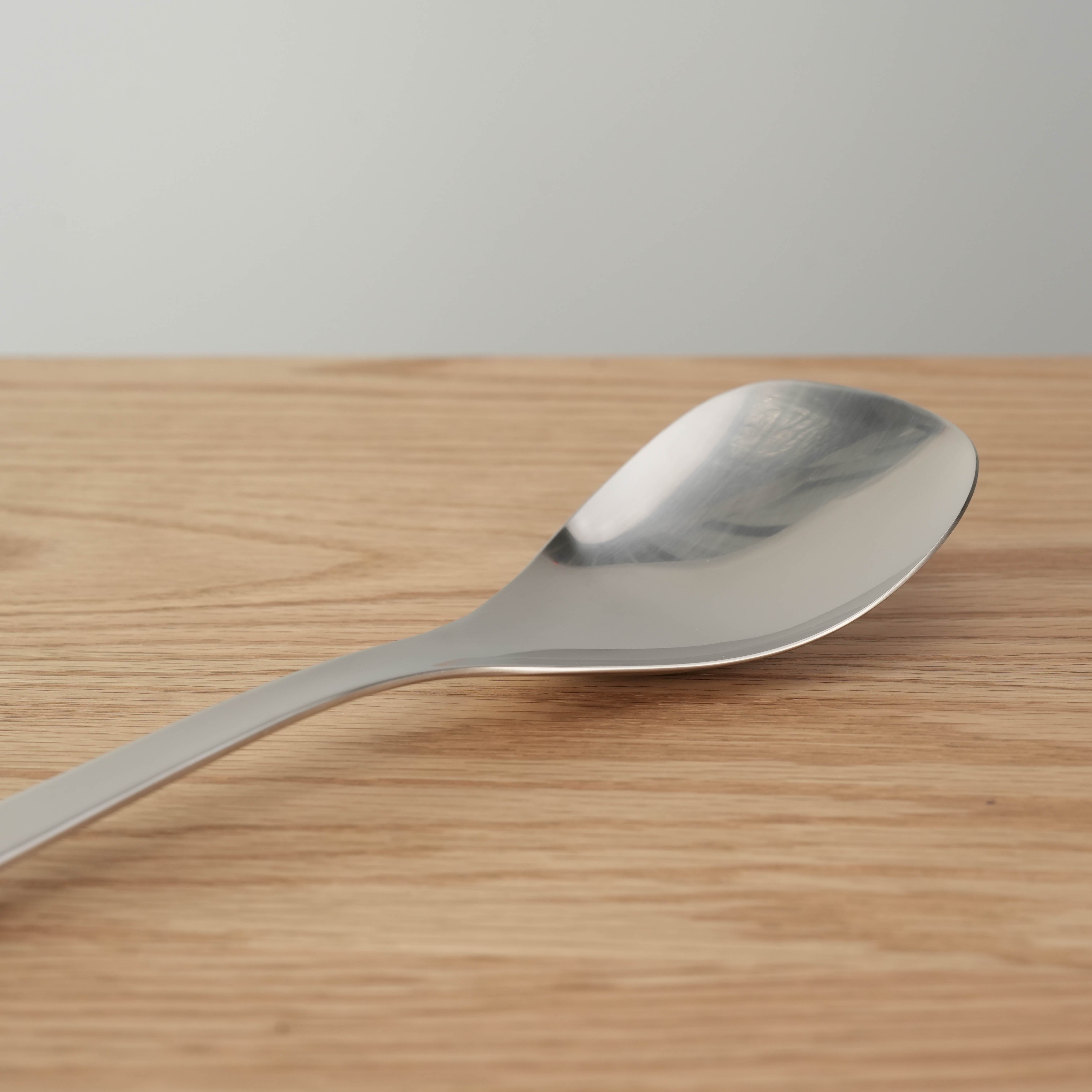 Close-up of Sori Yanagi Stainless Steel Serving Spoon, 24.8cm, highlighting its ergonomic curve and polished finish.