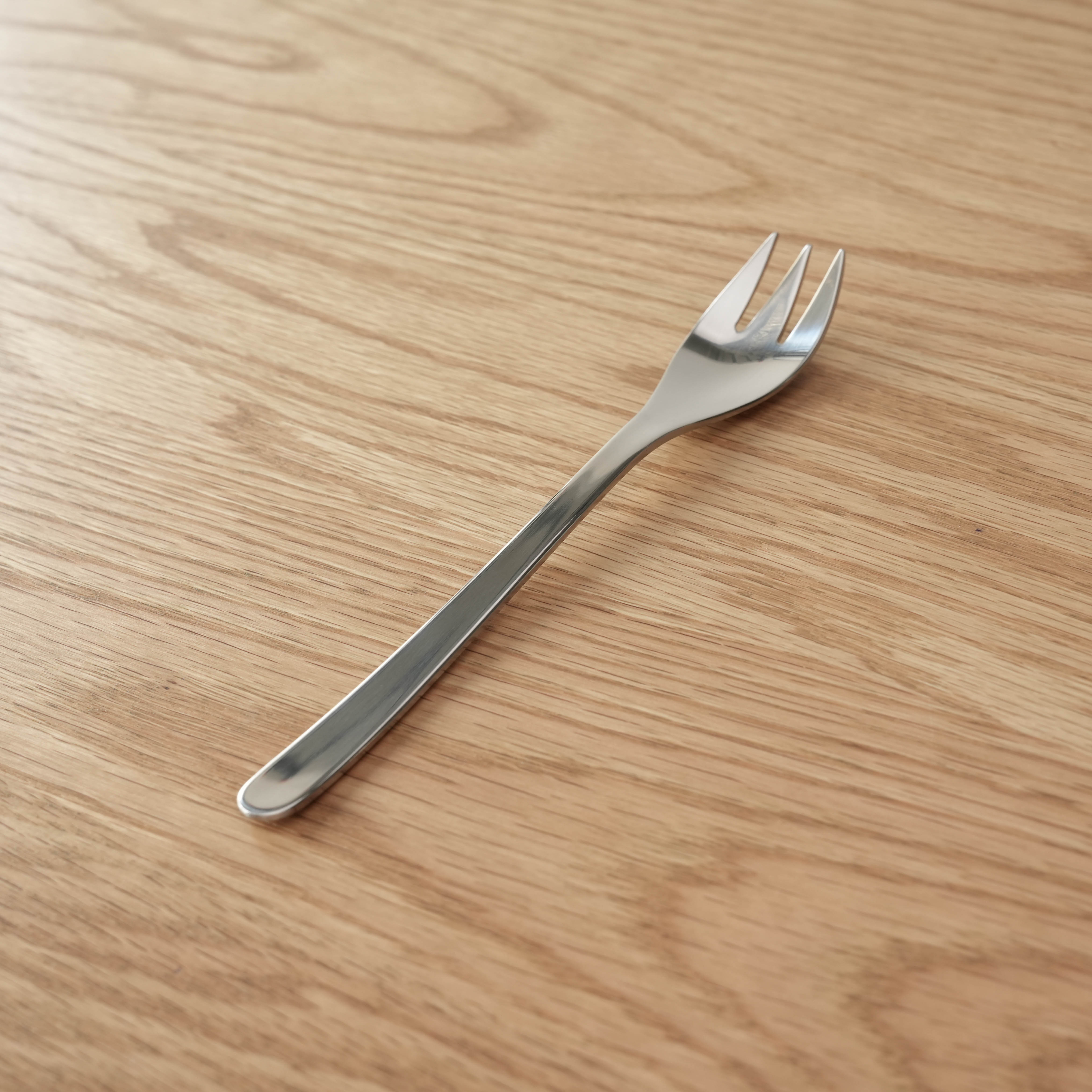Sori Yanagi Fork - Stainless Steel | Japanese Design dessert fork with sleek, ergonomic handle on wooden surface. Ideal for elegant table settings.