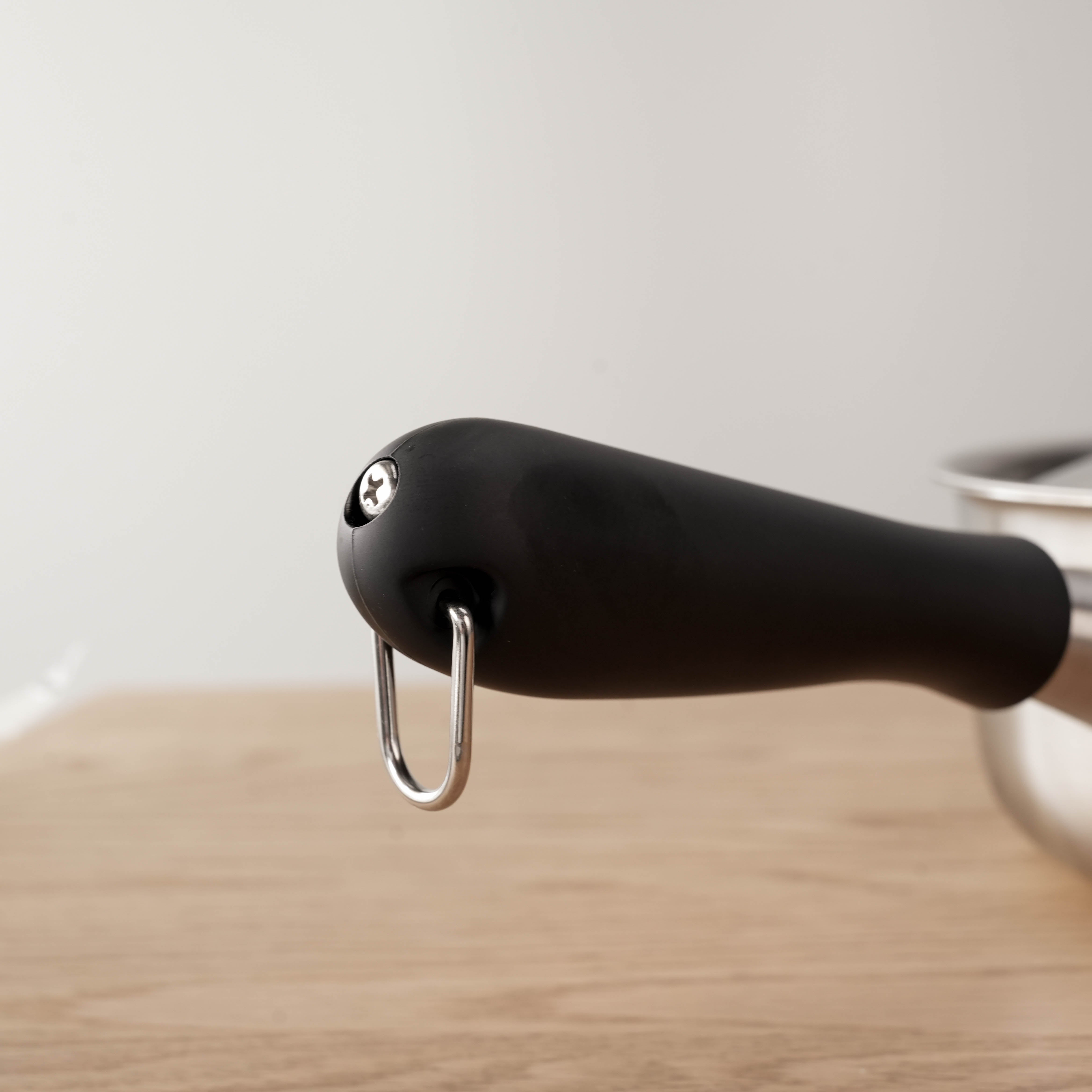 Close-up of Sori Yanagi Saucepan’s black handle with hanging hook, designed for comfort and convenient kitchen storage.