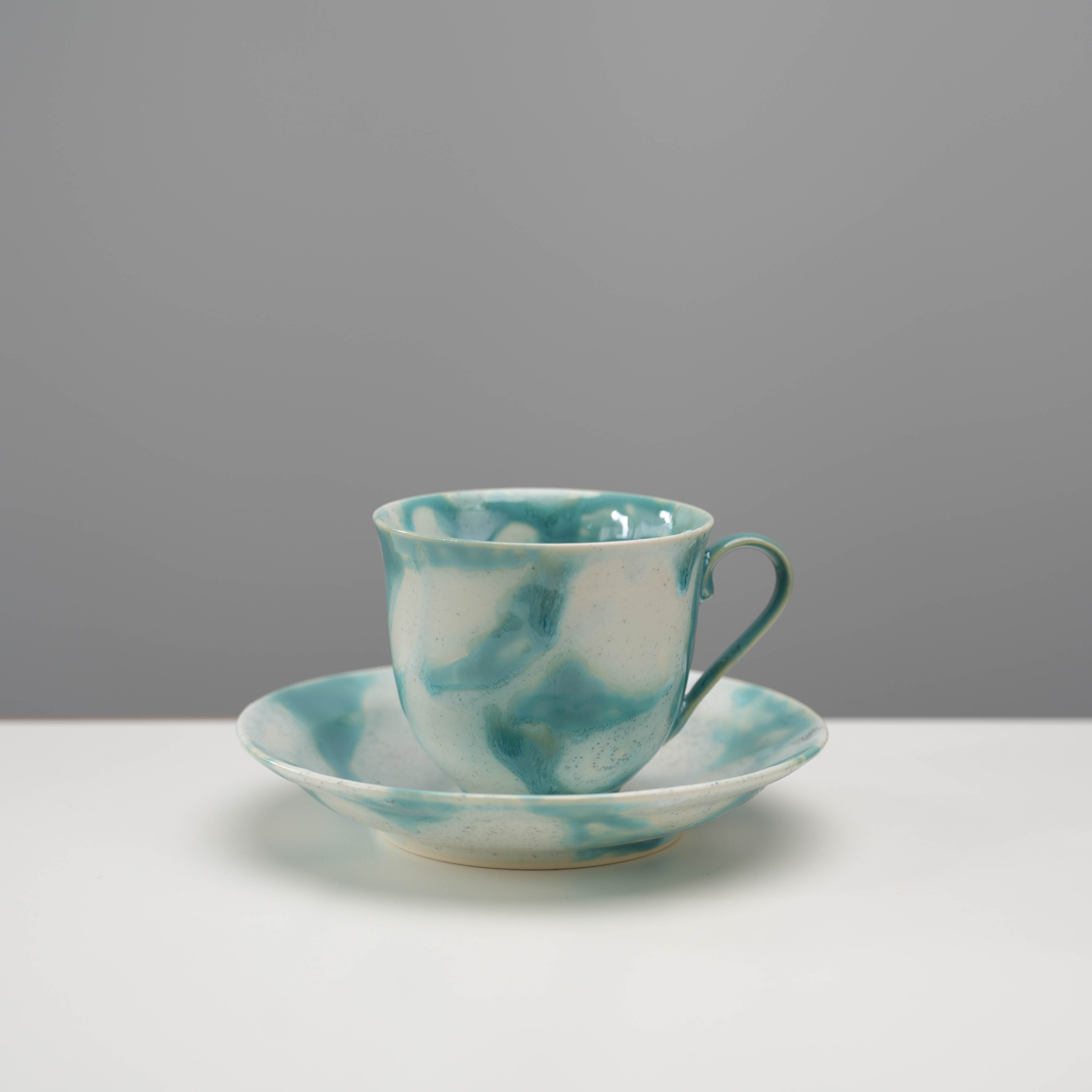 Arita Ware Shinryo New Green Coffee Cup & Saucer Set with flowing green glaze on white ceramic, showcasing Japanese design elegance.