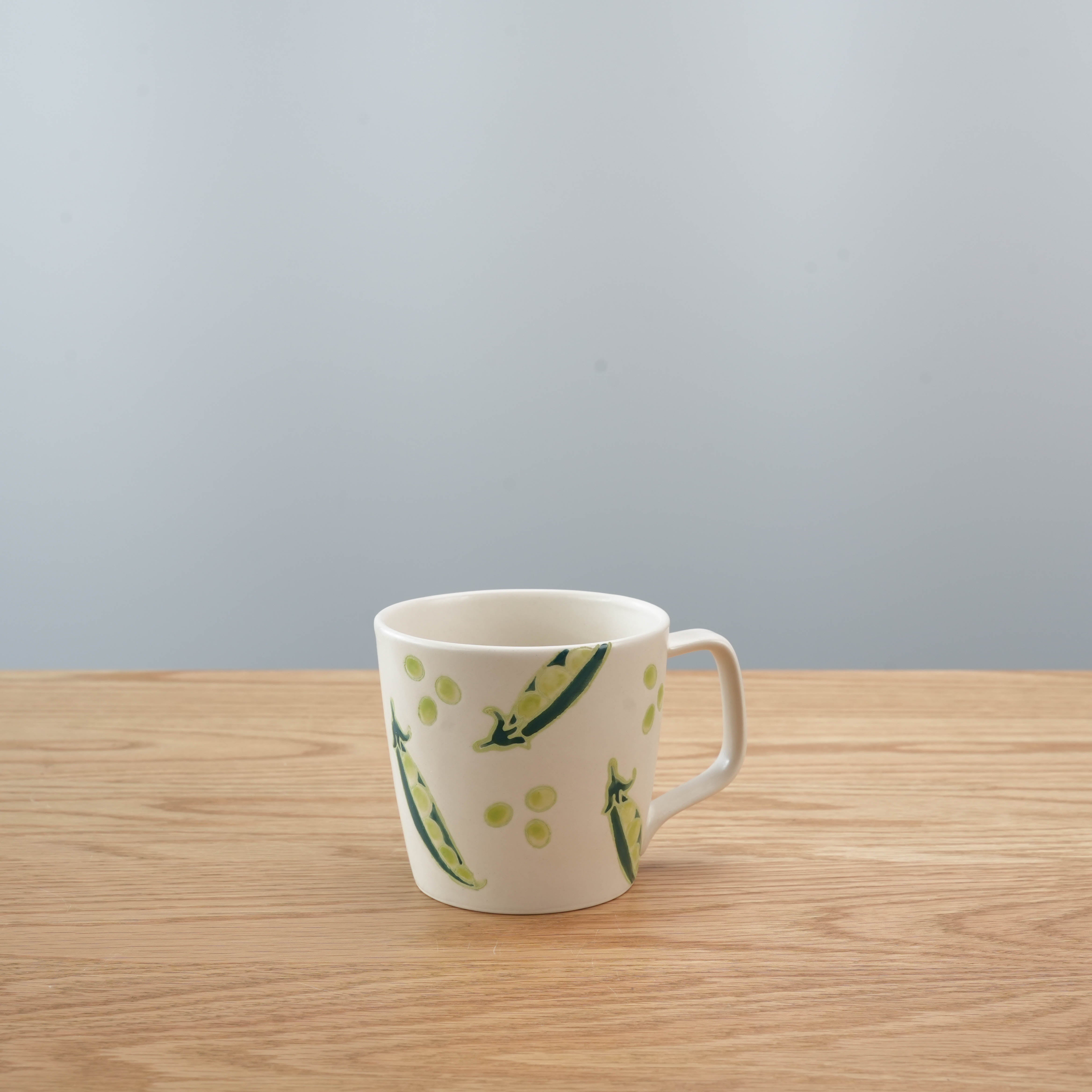 Hasami Ware Mug - Peas features hand-painted green pea pods on white ceramic, ideal for Japanese-style kitchen decor or gifting.