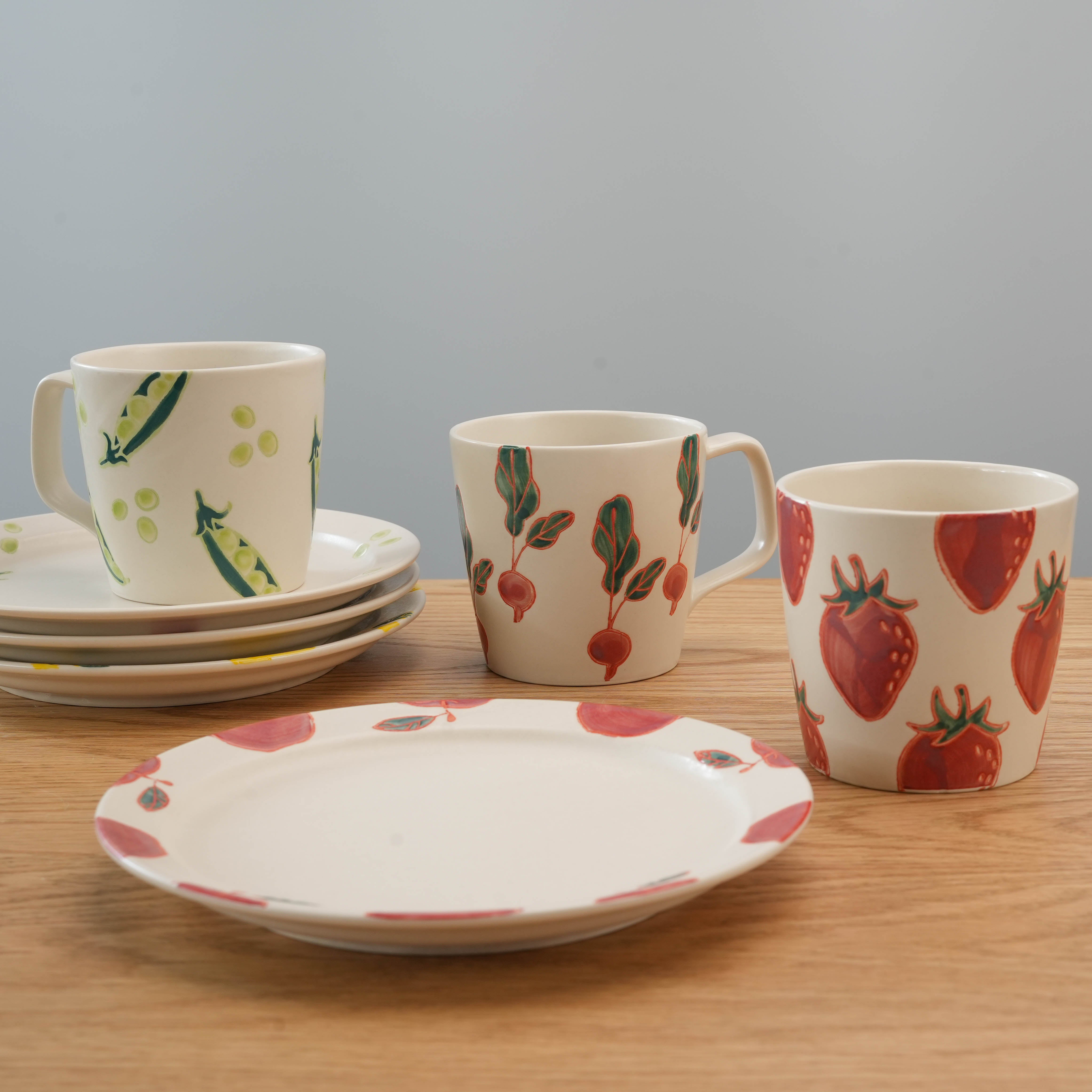 Assorted Hasami Ware Fresh Art tableware featuring lemon, strawberry, radish, and pea designs, showcasing Japanese ceramic mugs and plates.