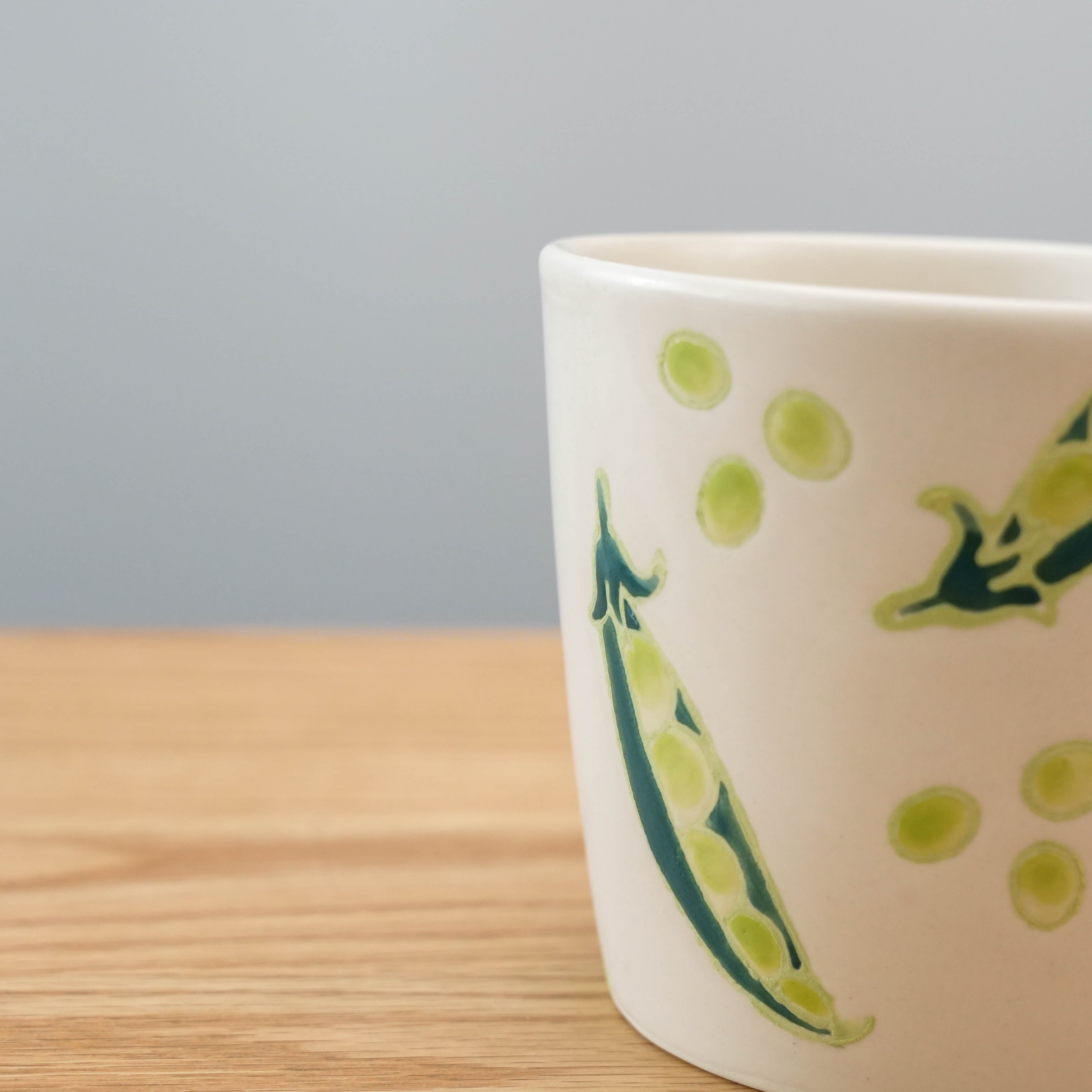 Close-up of Hasami Ware Mug - Peas showing detailed green pea illustrations, highlighting artisanal Japanese craftsmanship in drinkware.