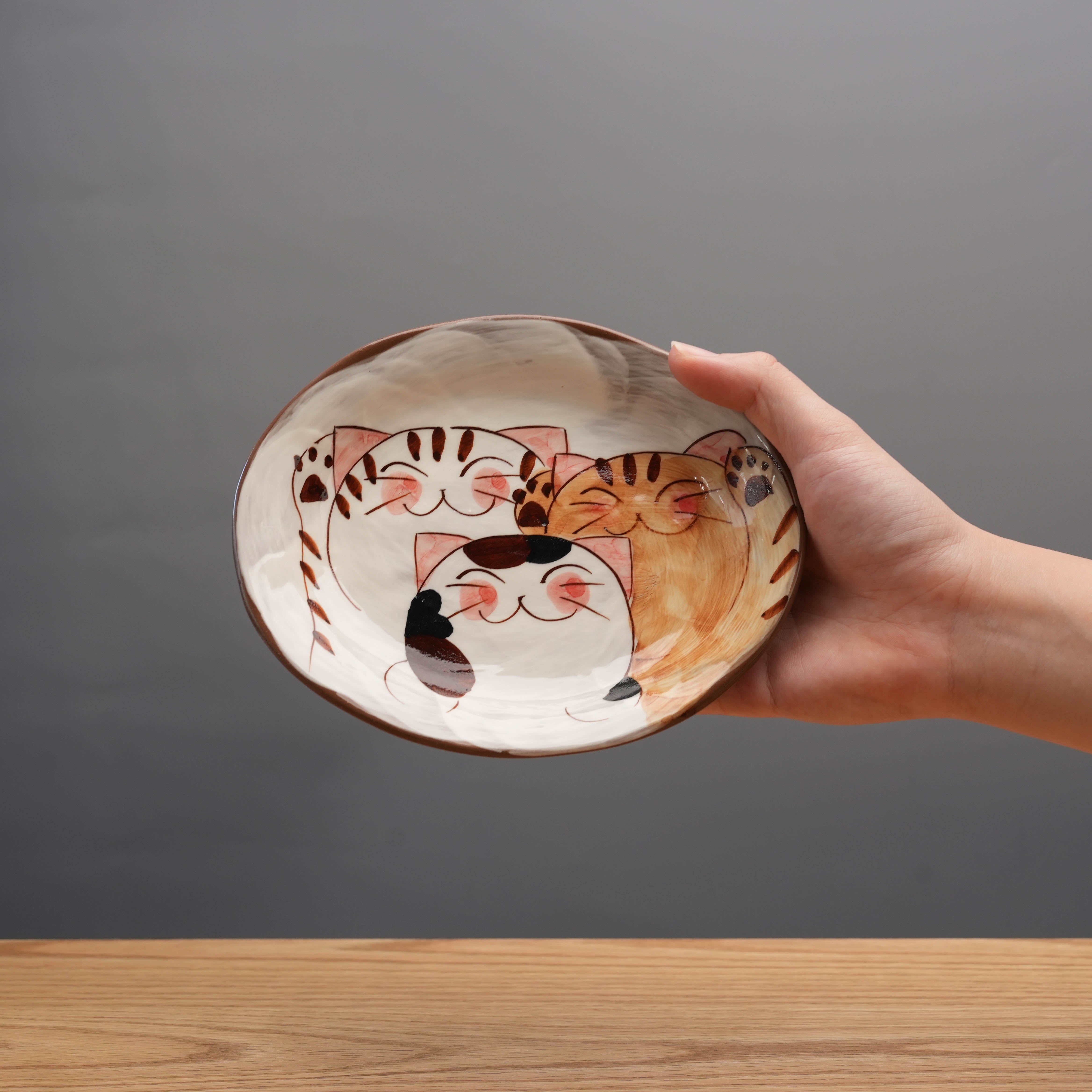 Oval Plate with Cats - Hasami Ware featuring three smiling cats in brown, orange, and black tones. Ideal for serving cake or snacks, handmade in Japan.