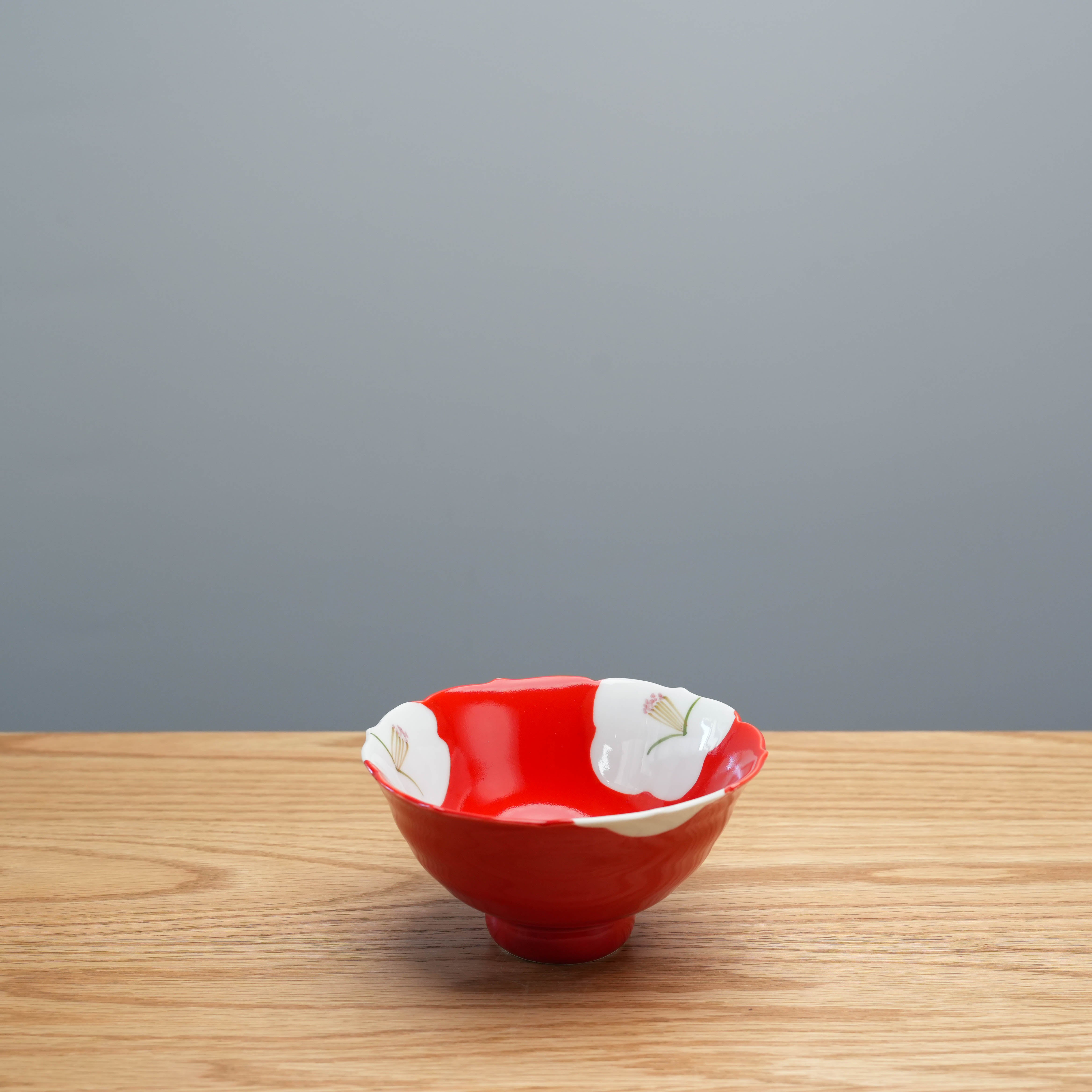 Red Arita Ware Plum Blossom Bowl with white petal rim and floral design, showcasing traditional Japanese craftsmanship for refined table settings.