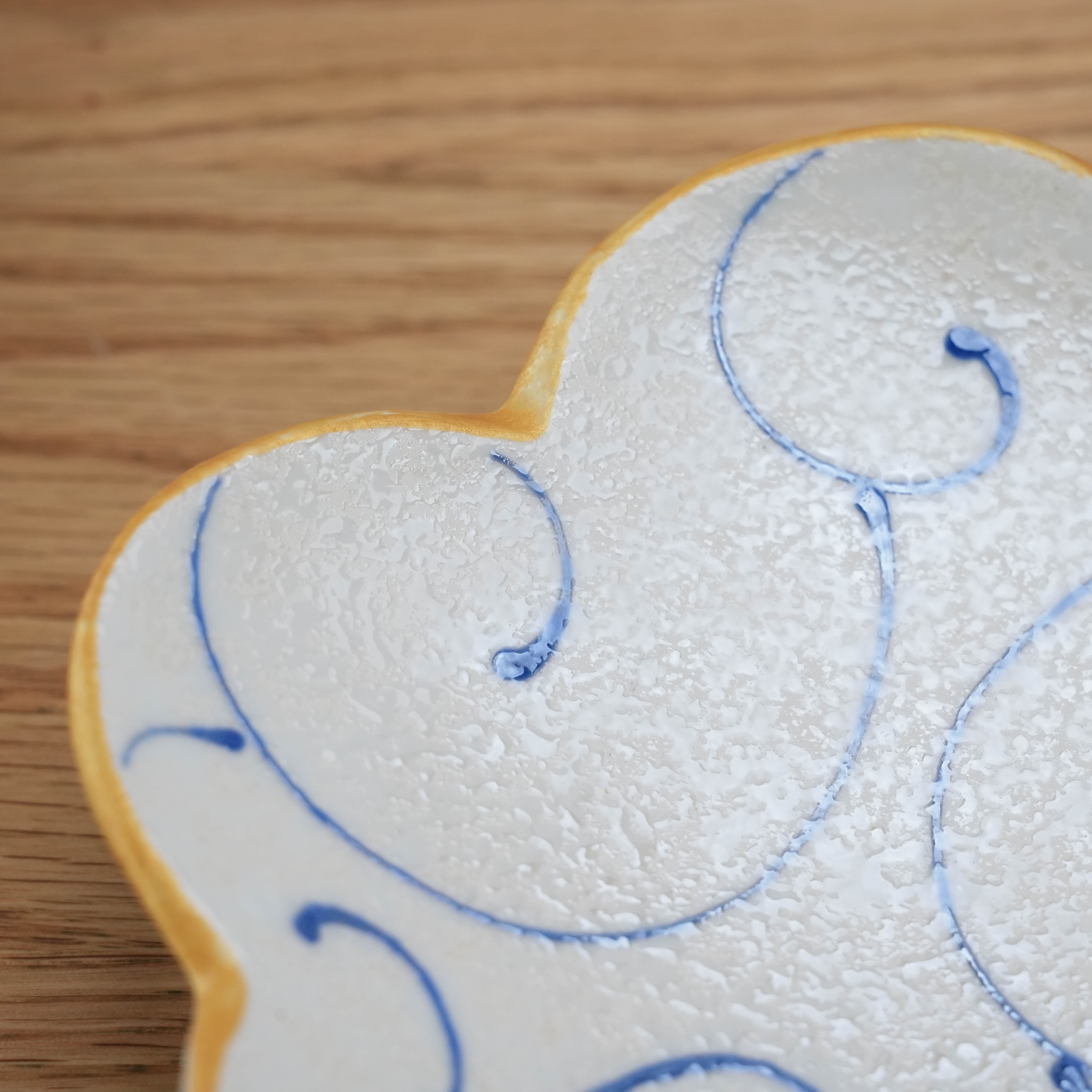 Close-up of Hirado Ware Cloud Plate with blue arabesque pattern and textured ceramic surface, showcasing fine Japanese craftsmanship.
