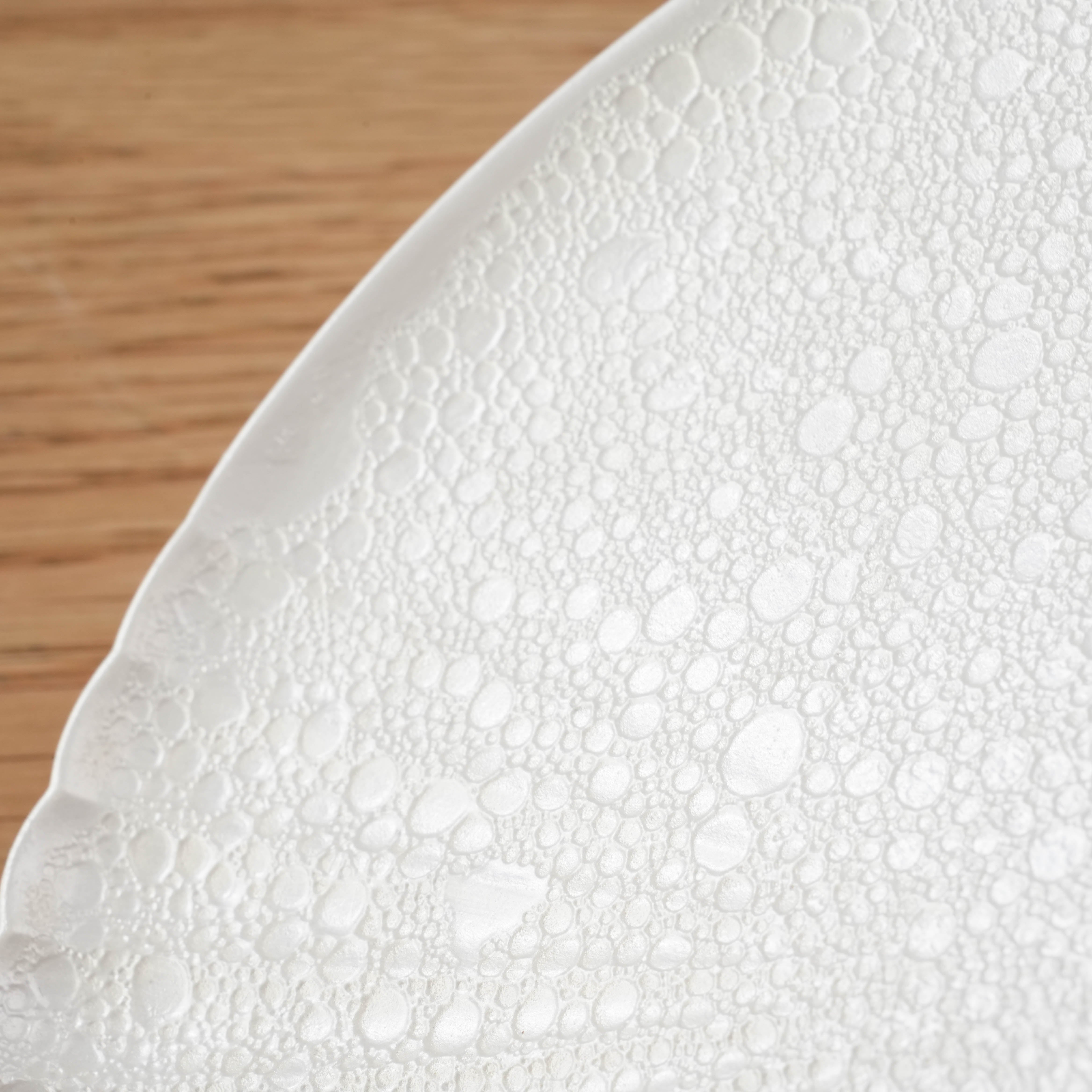 Close-up of Arita Ware plate showing rare bubble texture and chrysanthemum carving, highlighting its unique Japanese craftsmanship.