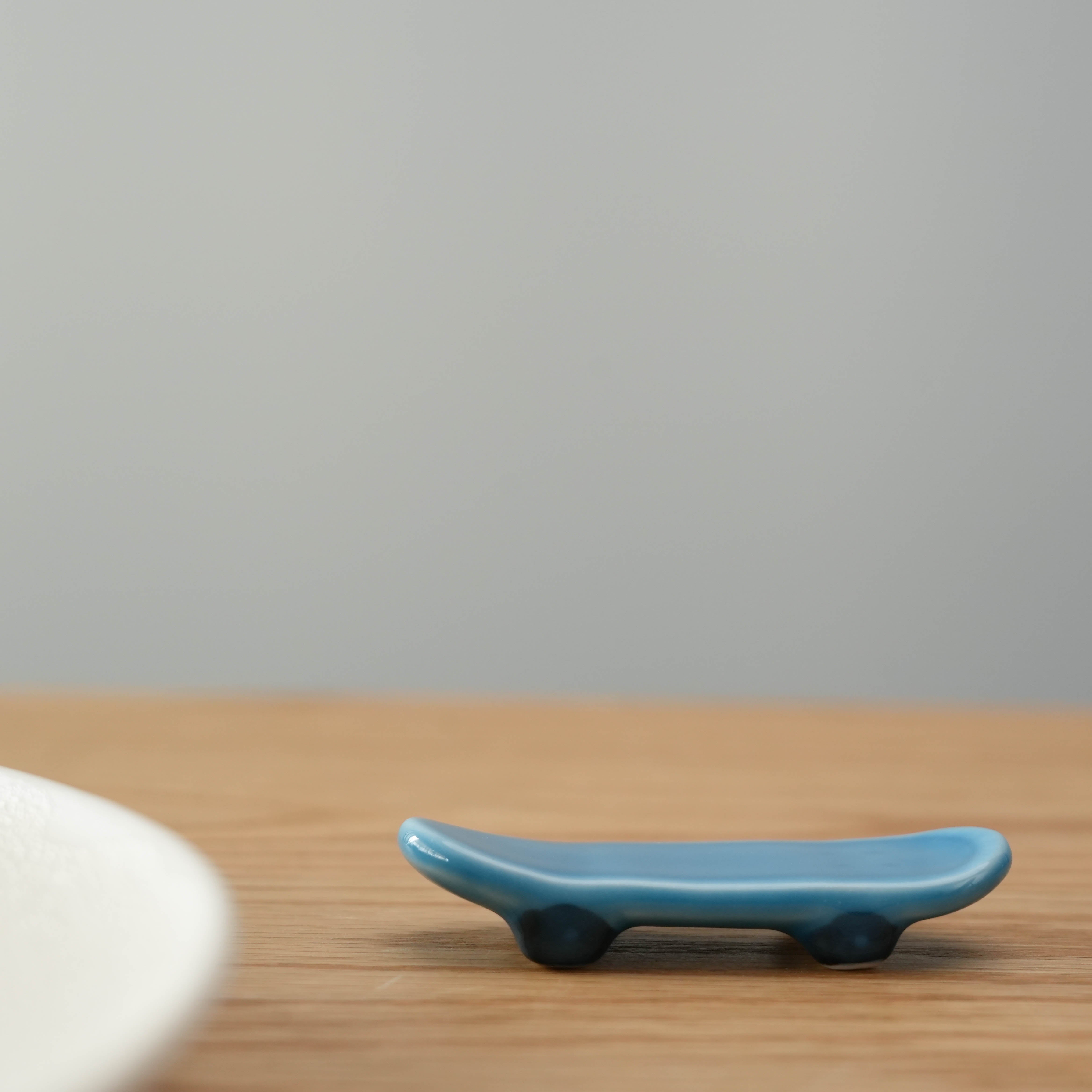 Arita Ware Skateboard Chopstick Rest in glossy blue ceramic, shaped like a mini skateboard, made in Japan for stylish table settings.
