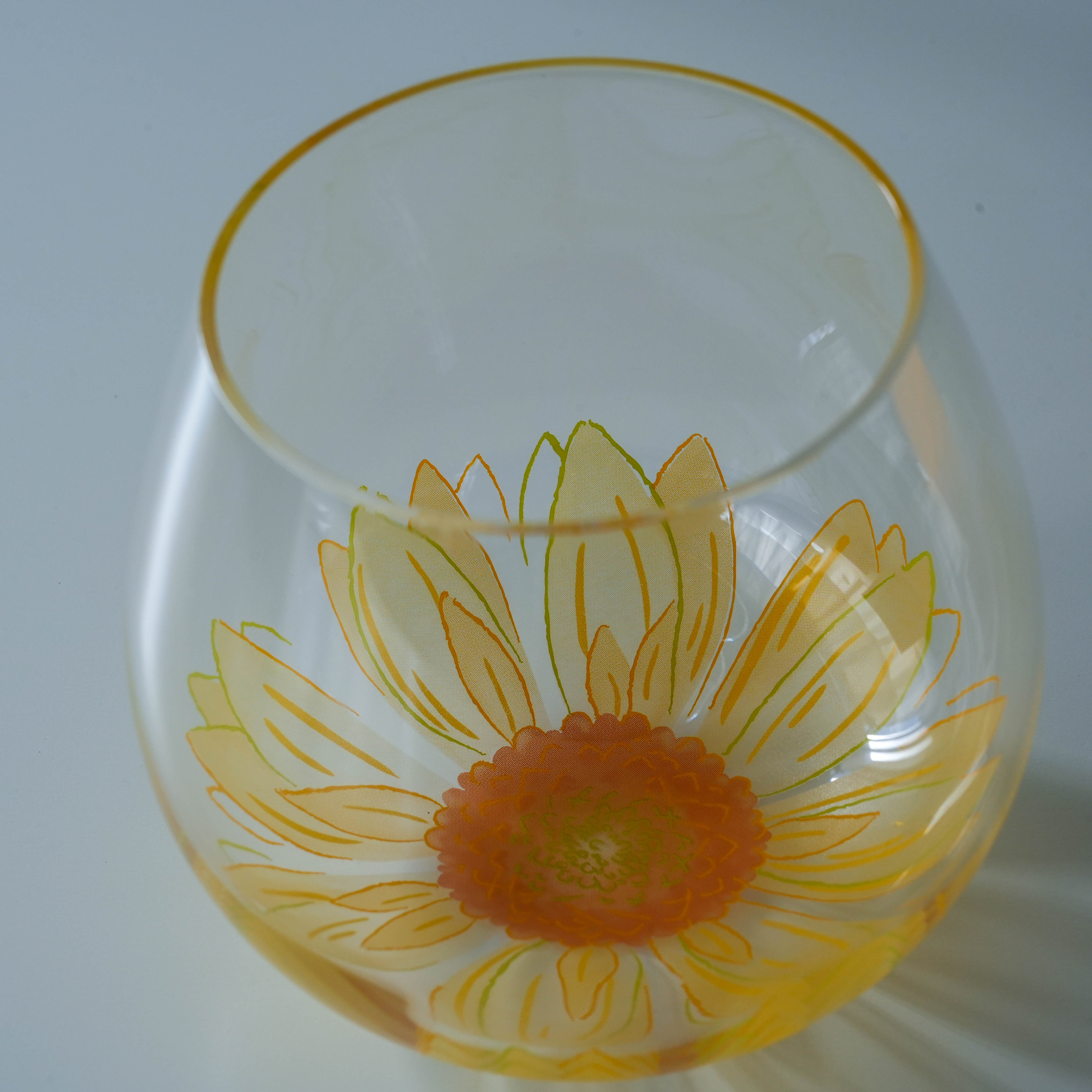 Close-up of Toyo-Sasaki Fleurir Glass Tumbler showcasing intricate yellow Gerbera petals, symbolizing hope and craftsmanship.