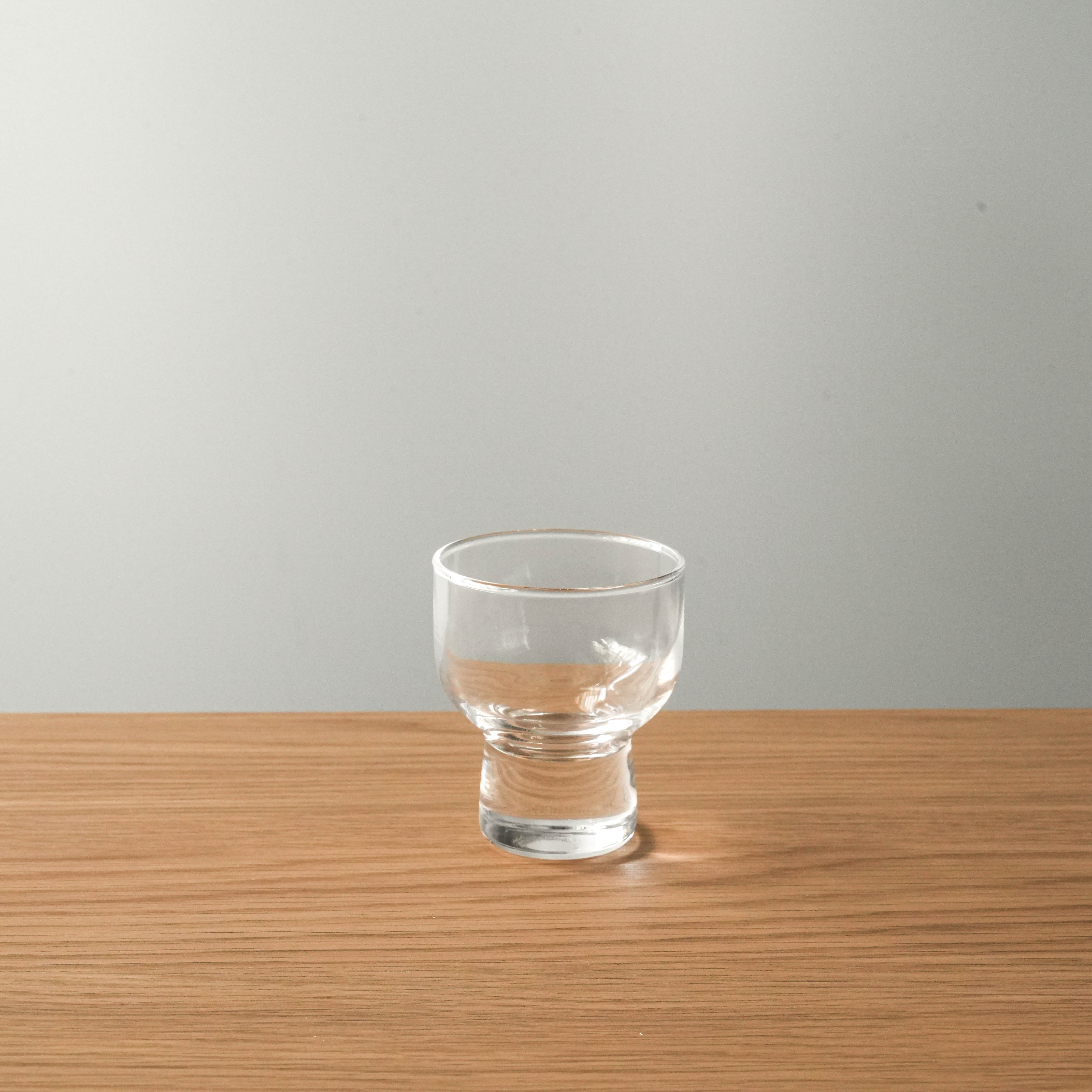 Toyo-Sasaki Sake Cup Set-Glass Sake Cup | Made in Japan. Minimalist sake cup on wooden surface, part of a 6-piece set perfect for home or gifting.