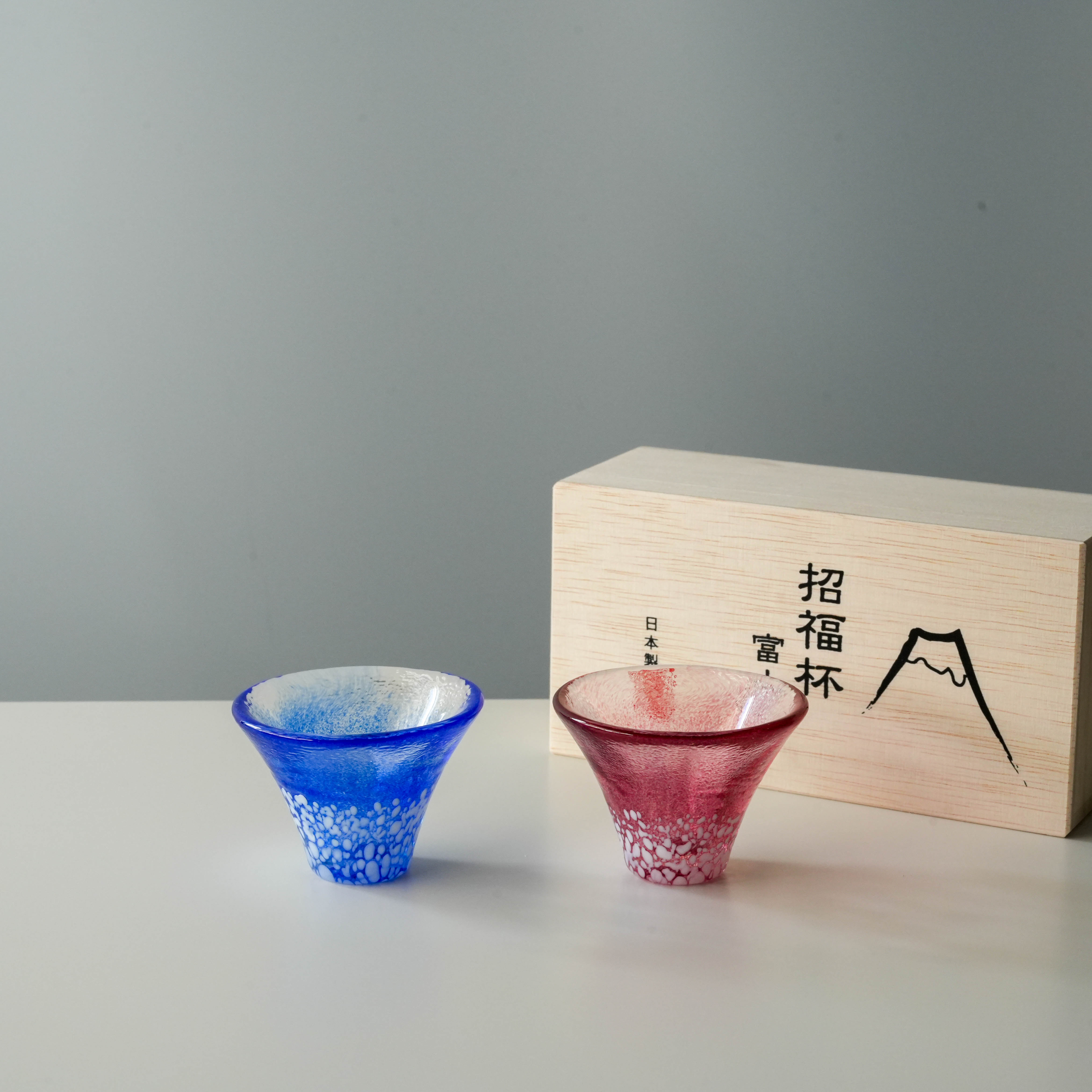 Handmade Fuji Sake Cup Set in blue and red with Mt. Fuji design, displayed with wooden gift box. Perfect for gifting or Japanese tableware.