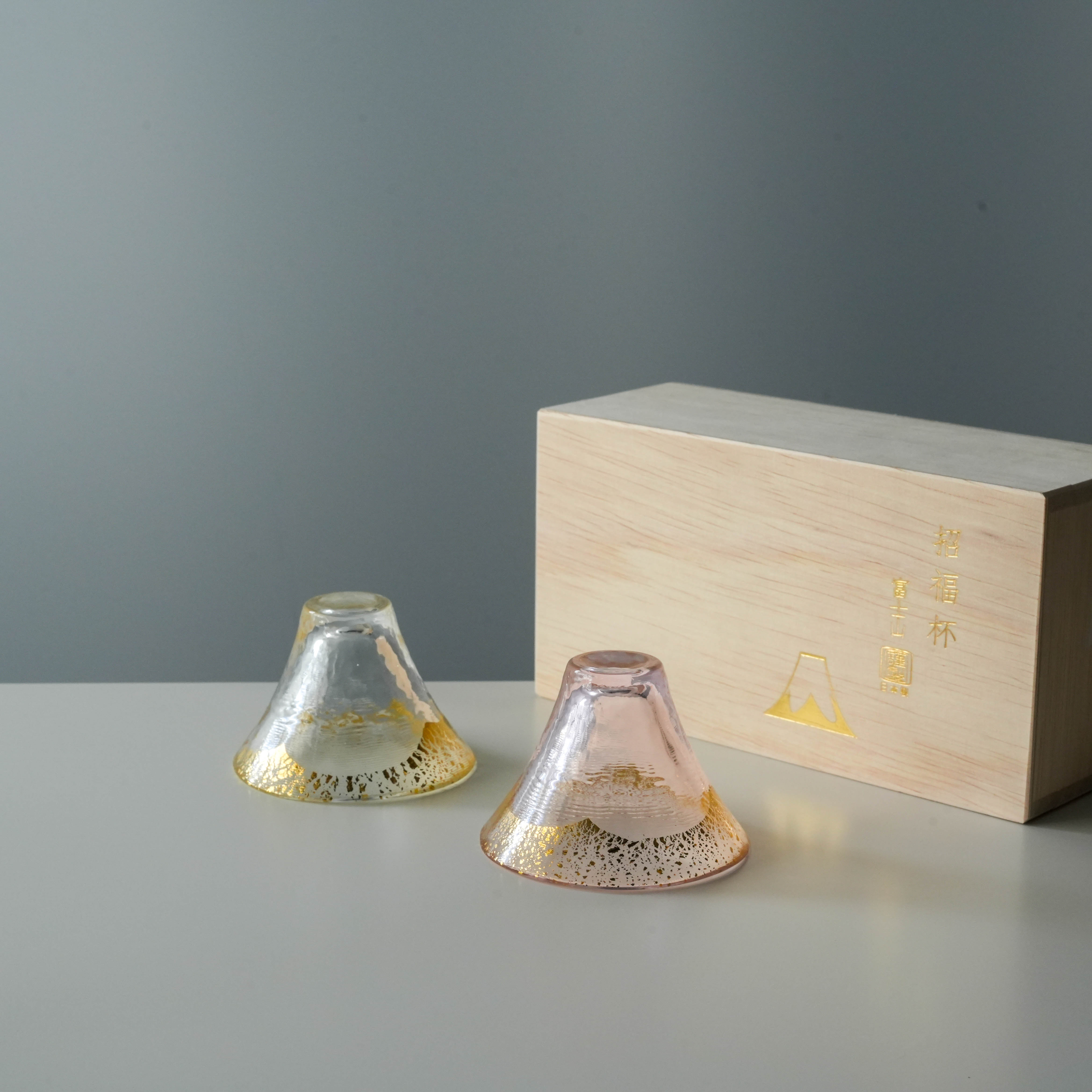 Toyo-Sasaki Sake Cup Set - Mt. Fuji design in pink and clear glass with gold accents, displayed with wooden gift box. Ideal for elegant gifting.