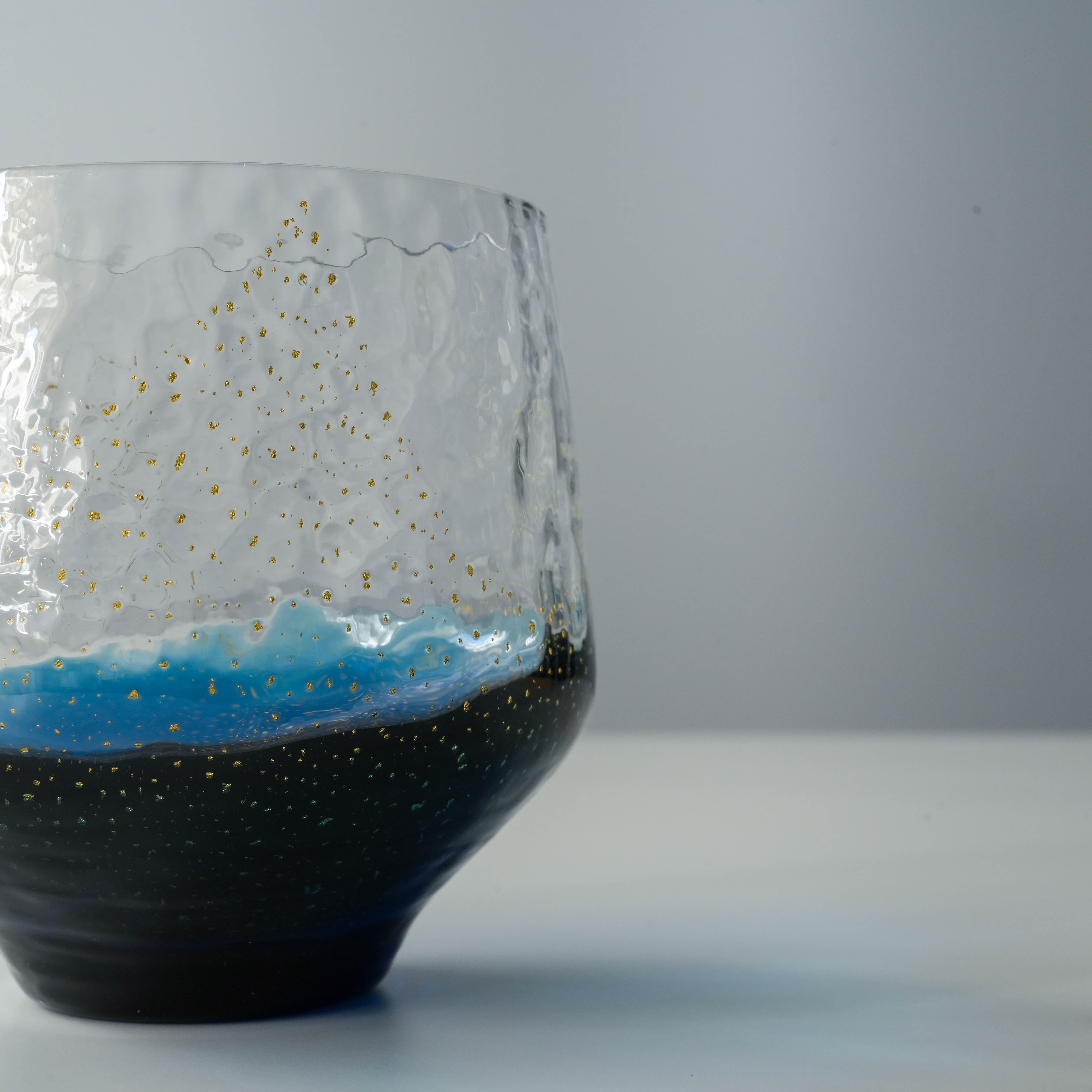 Toyo-Sasaki Sapphire Tumbler side profile with hammered glass texture and shimmering gold flecks over a deep blue base.