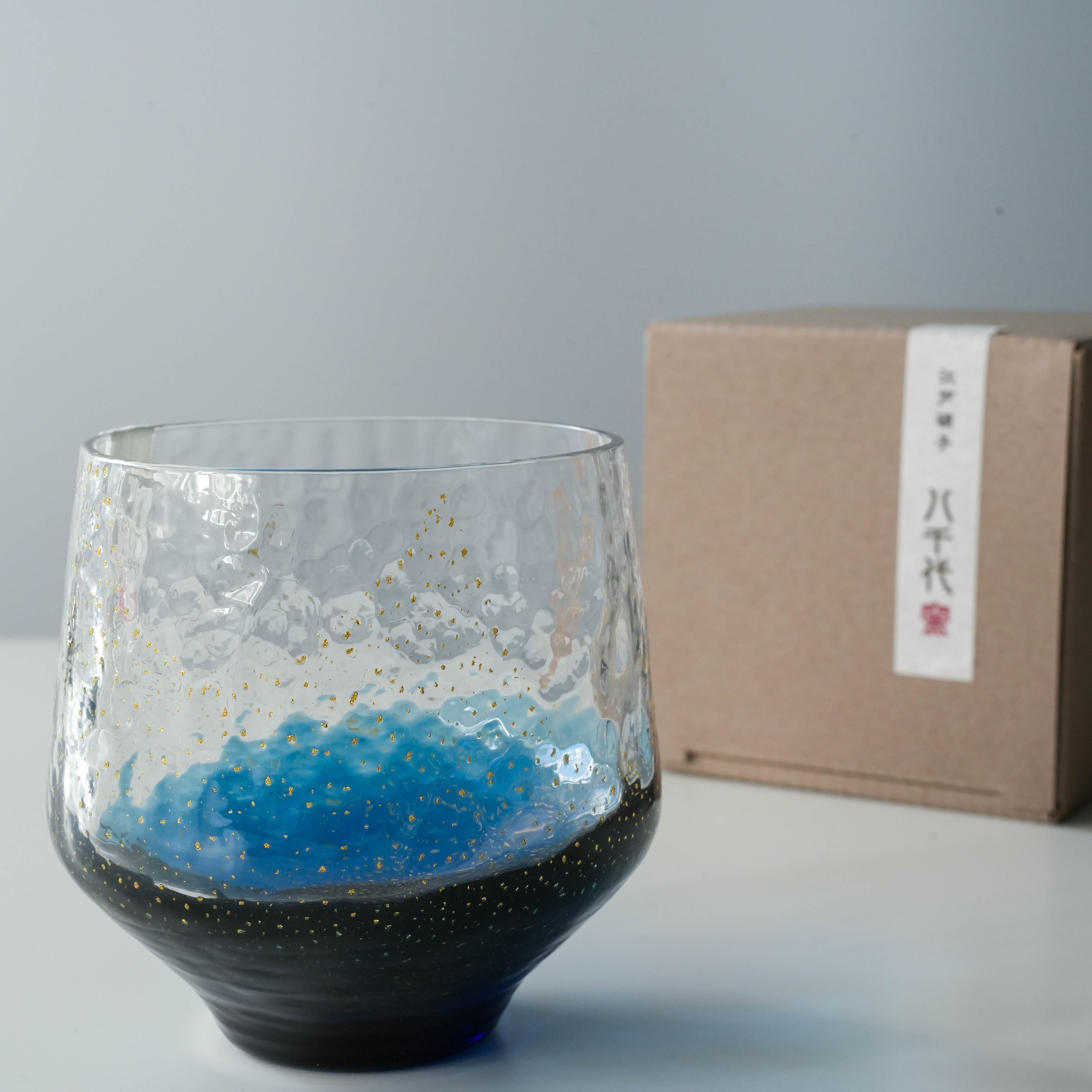 Close-up of Toyo-Sasaki Sapphire Tumbler with gift box, featuring traditional Japanese Edo glass design with gold flecks.
