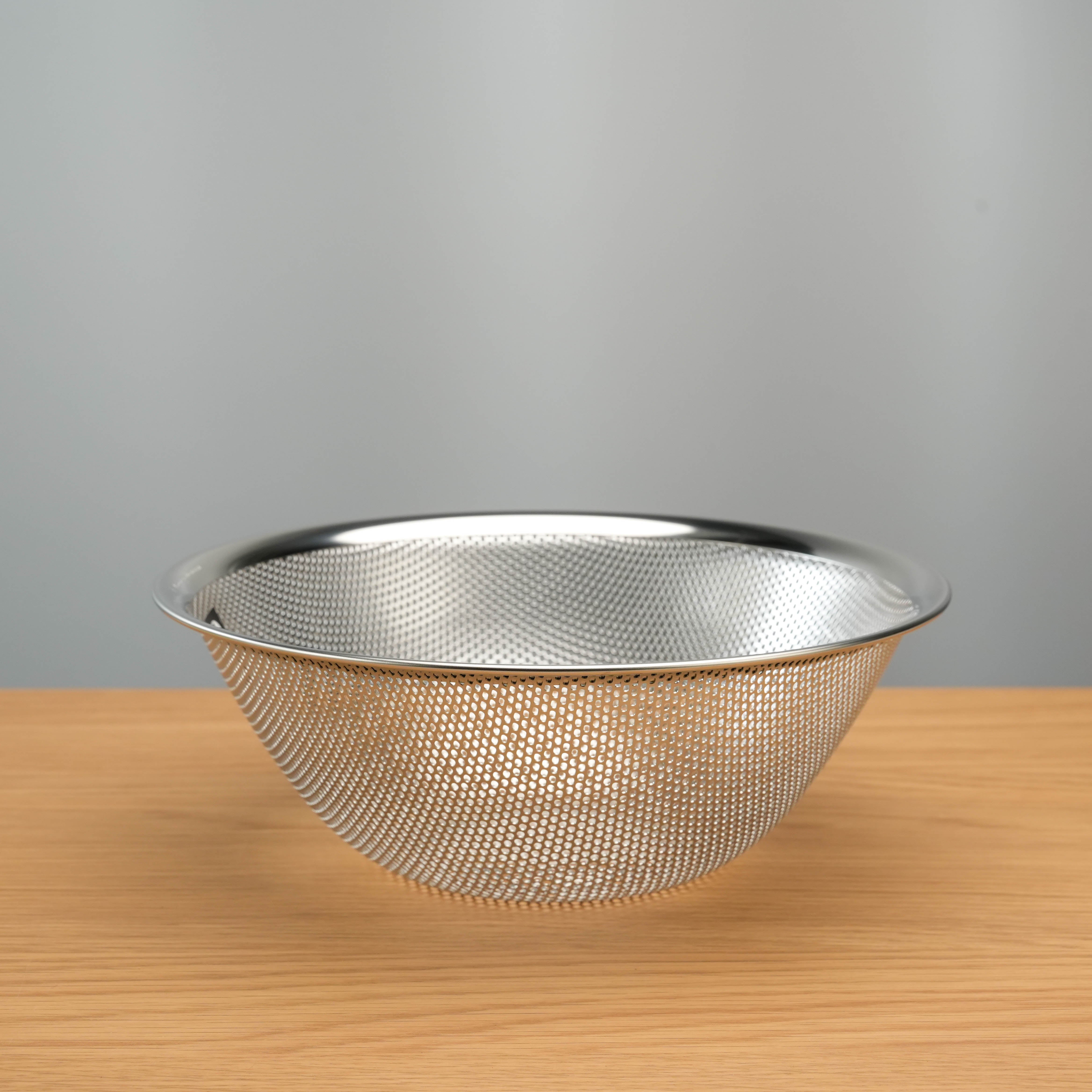 Single Sori Yanagi Stainless Steel Perforated Colander with fine mesh pattern, perfect for straining vegetables or pasta with ease.