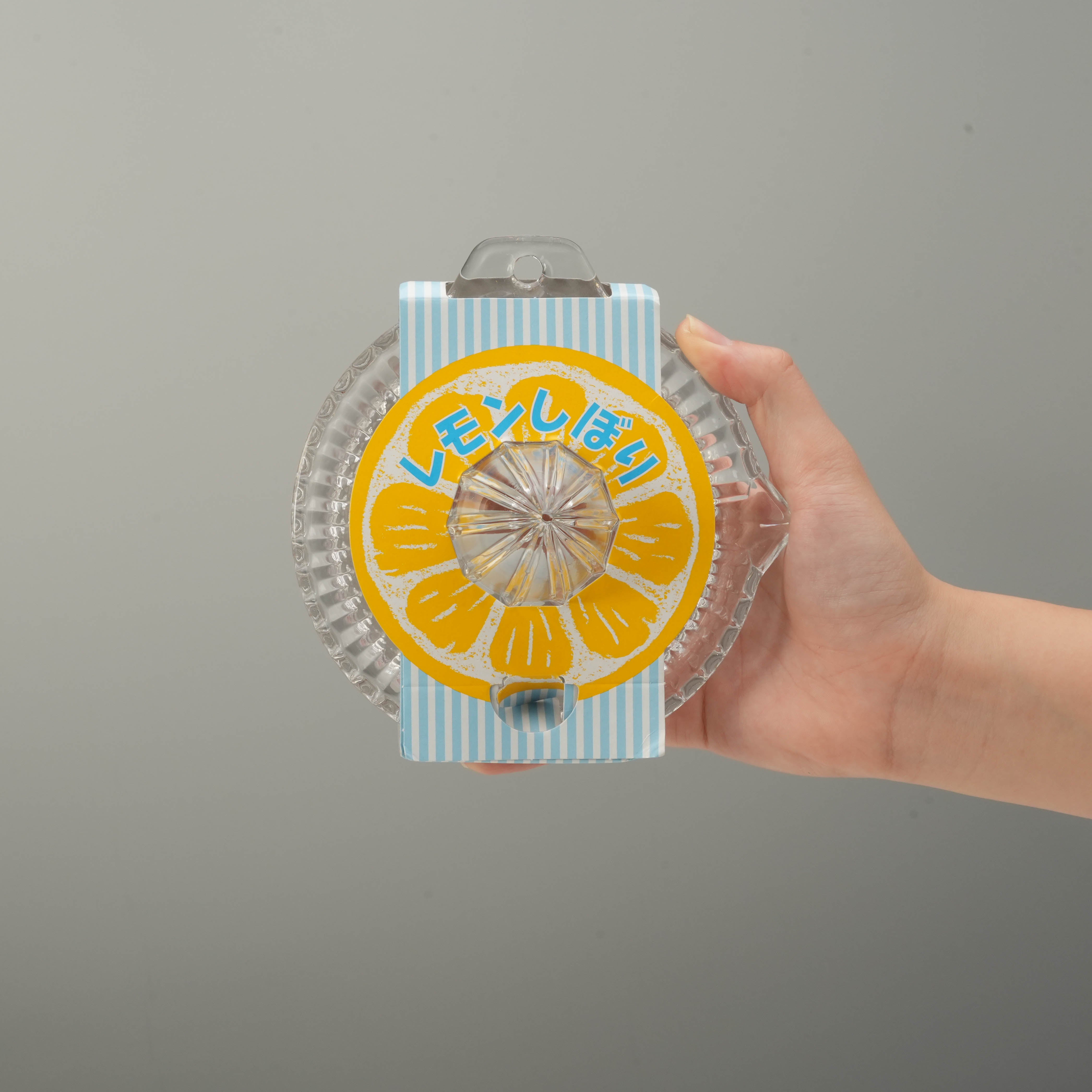 Hand holding Toyo-Sasaki Lemon Squeezer - Round Glass Extractor, showcasing compact size and ergonomic design for home kitchens.