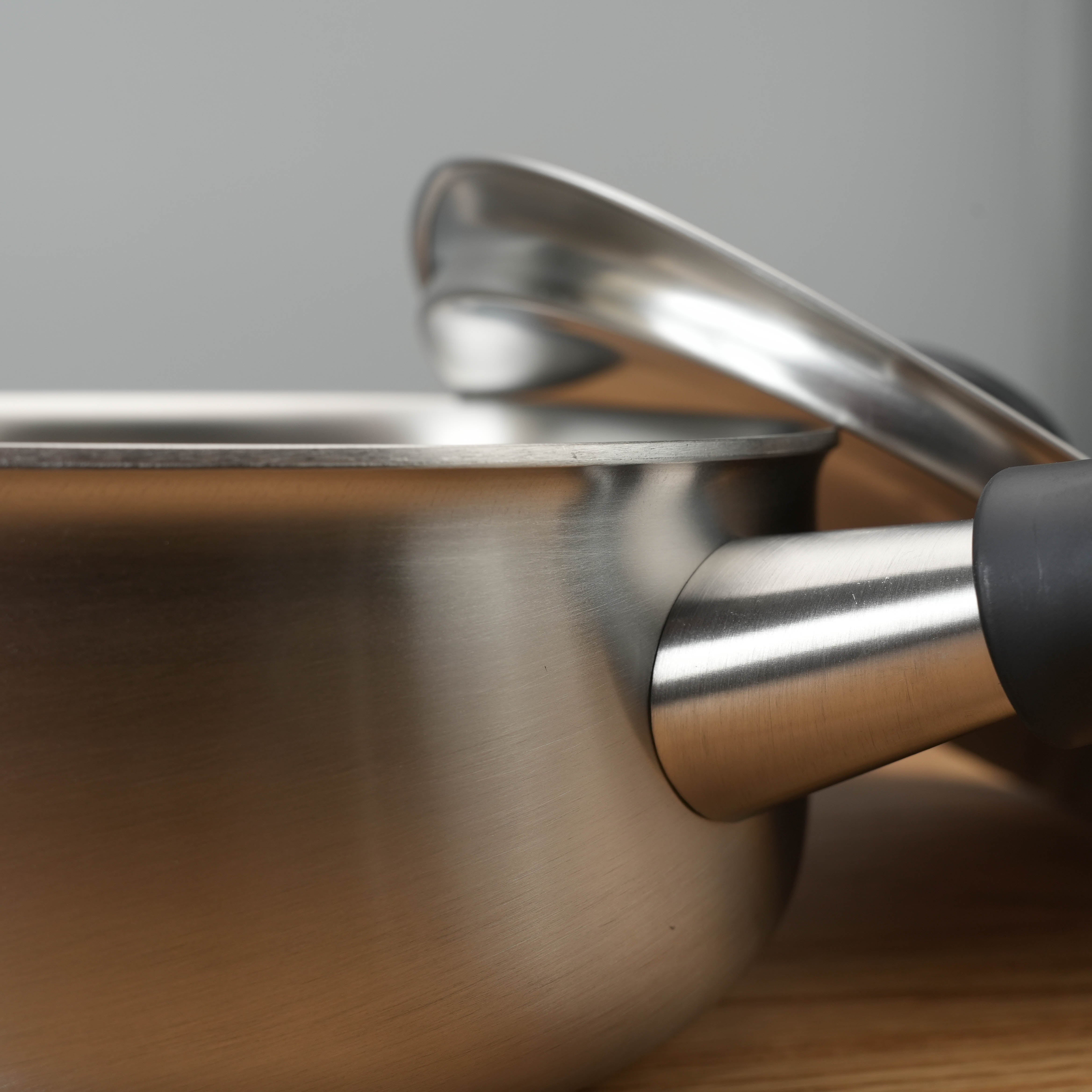 Close-up of handle and rim on Sori Yanagi 3-Ply Stainless Steel Saucepan, highlighting premium build and induction-ready base.