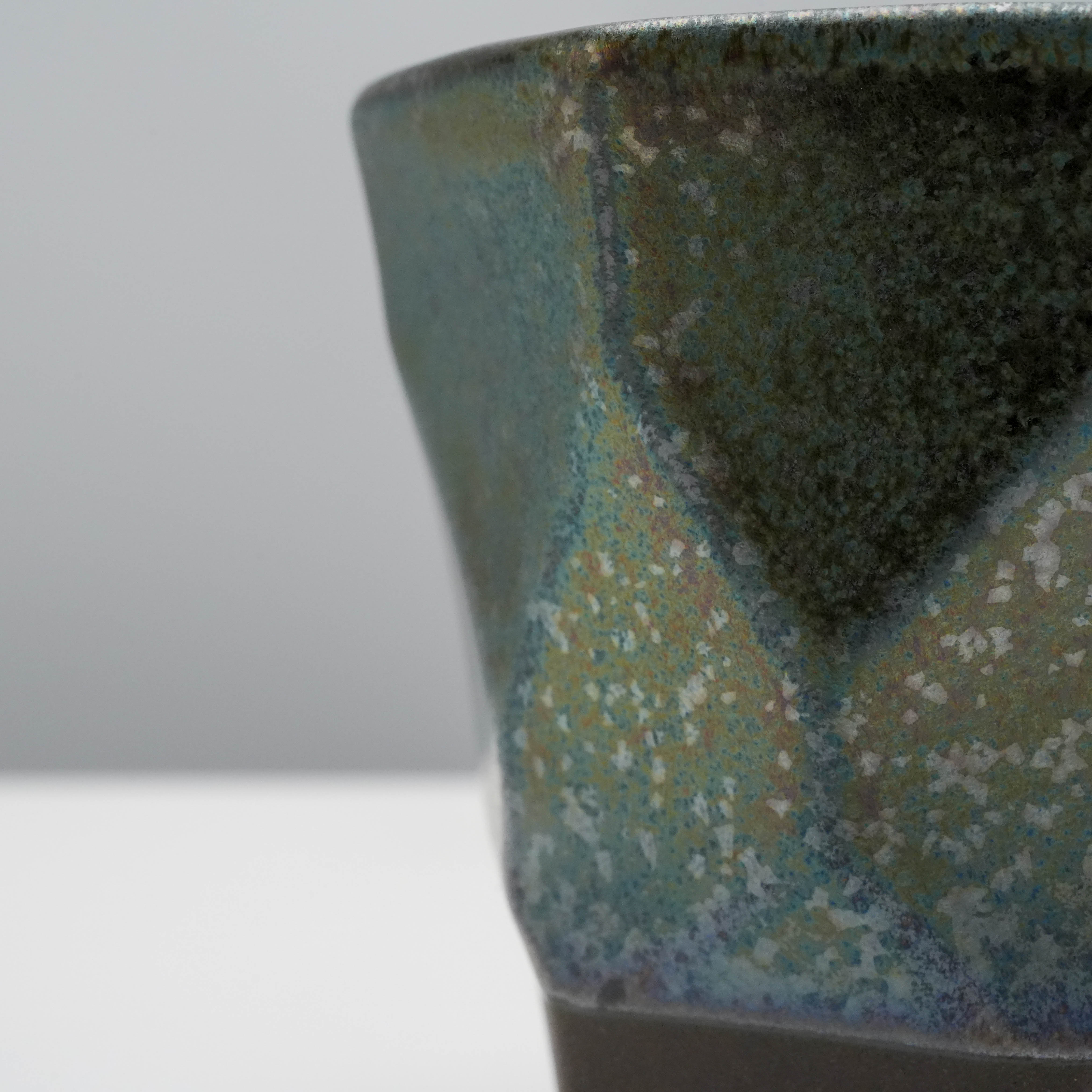 Detailed texture of Tsubame Kobo Free Cup - Metal Cup with shimmering metallic glaze over black clay, emphasizing handcrafted quality.