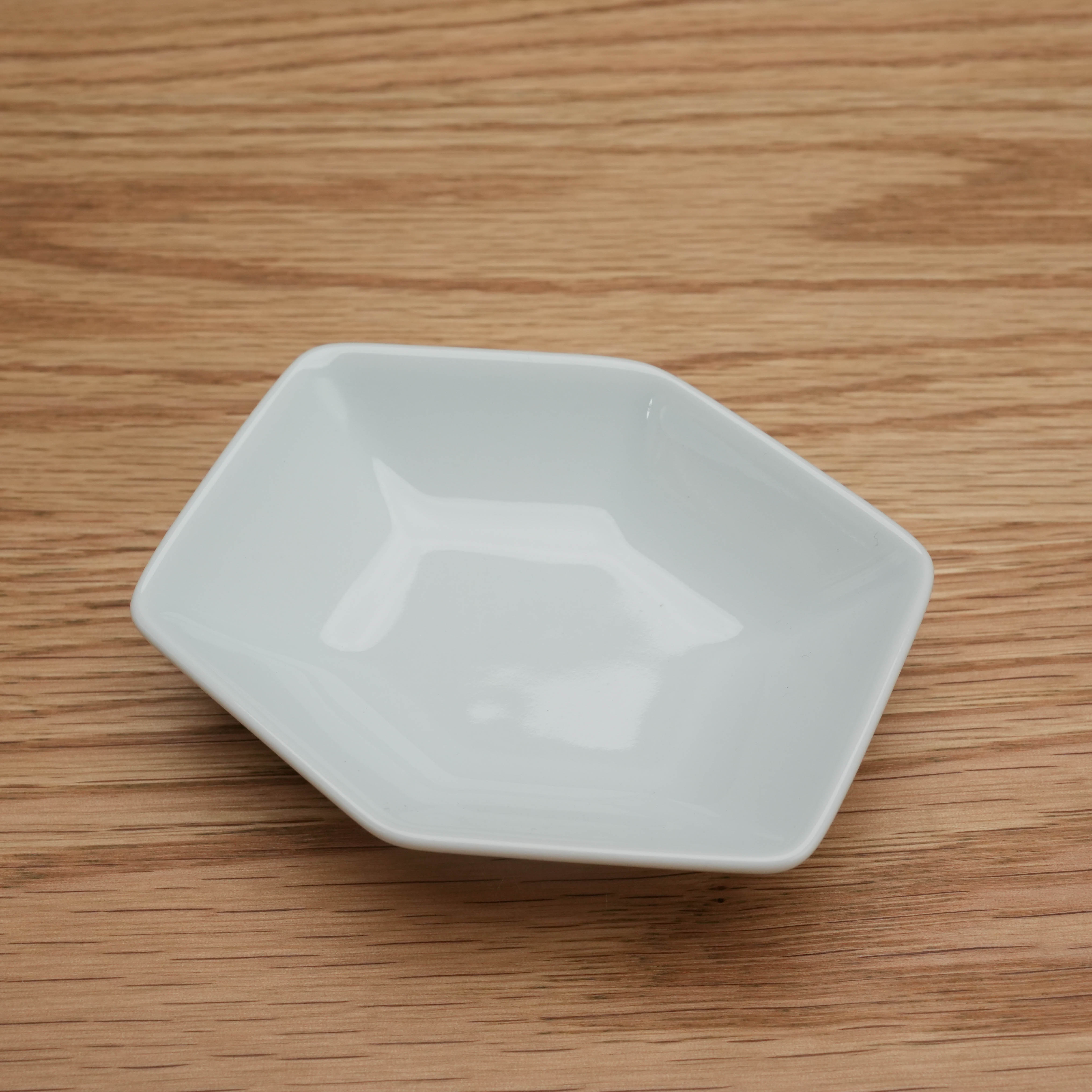 Hakusan Kikkou Sauce Dish in white Hasami ware with tortoiseshell-inspired hexagonal shape, ideal for condiments and dipping sauces.
