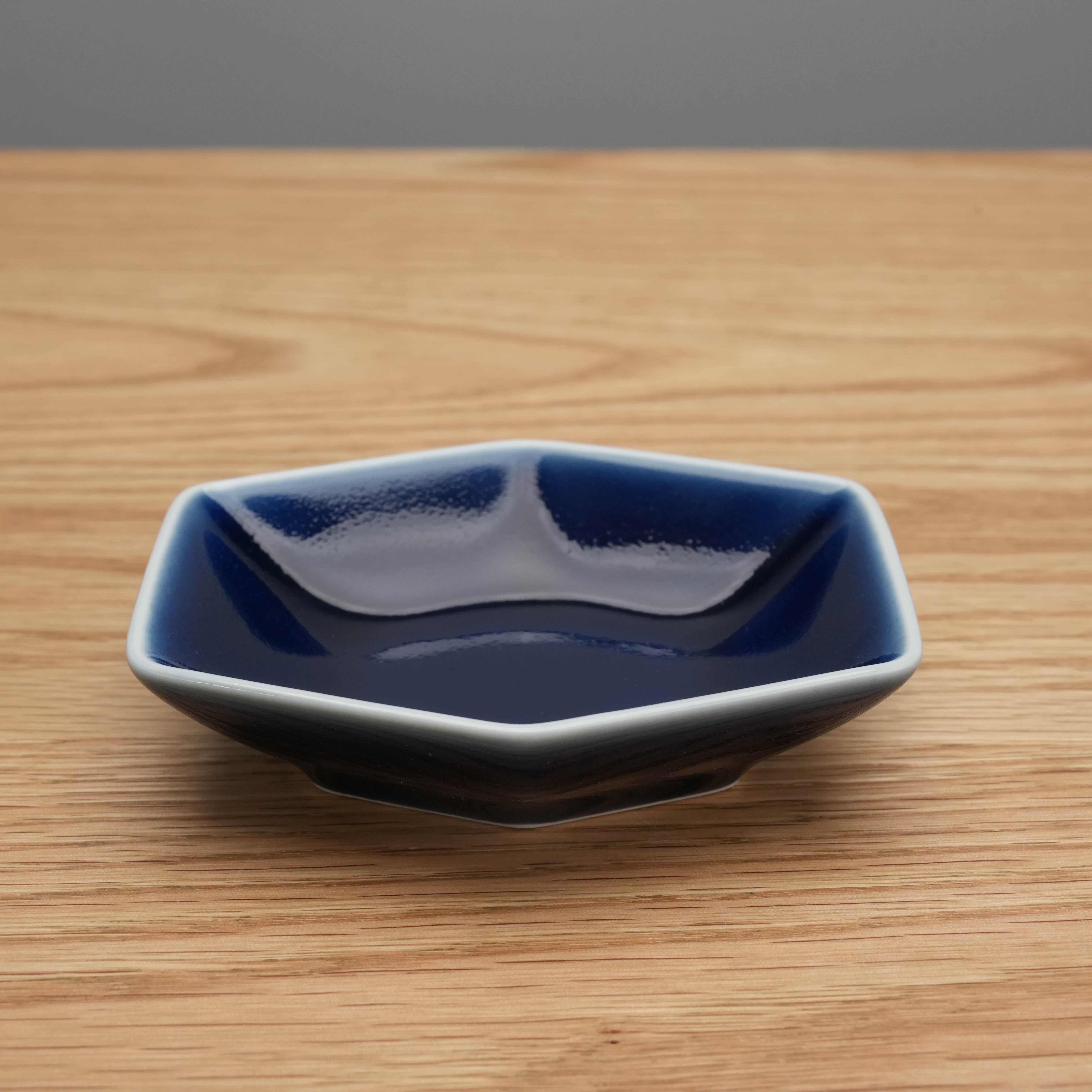 Side view of navy blue Hakusan Kikkou Sauce Dish in Hasami ware, showcasing its elegant hexagonal shape and glossy finish.