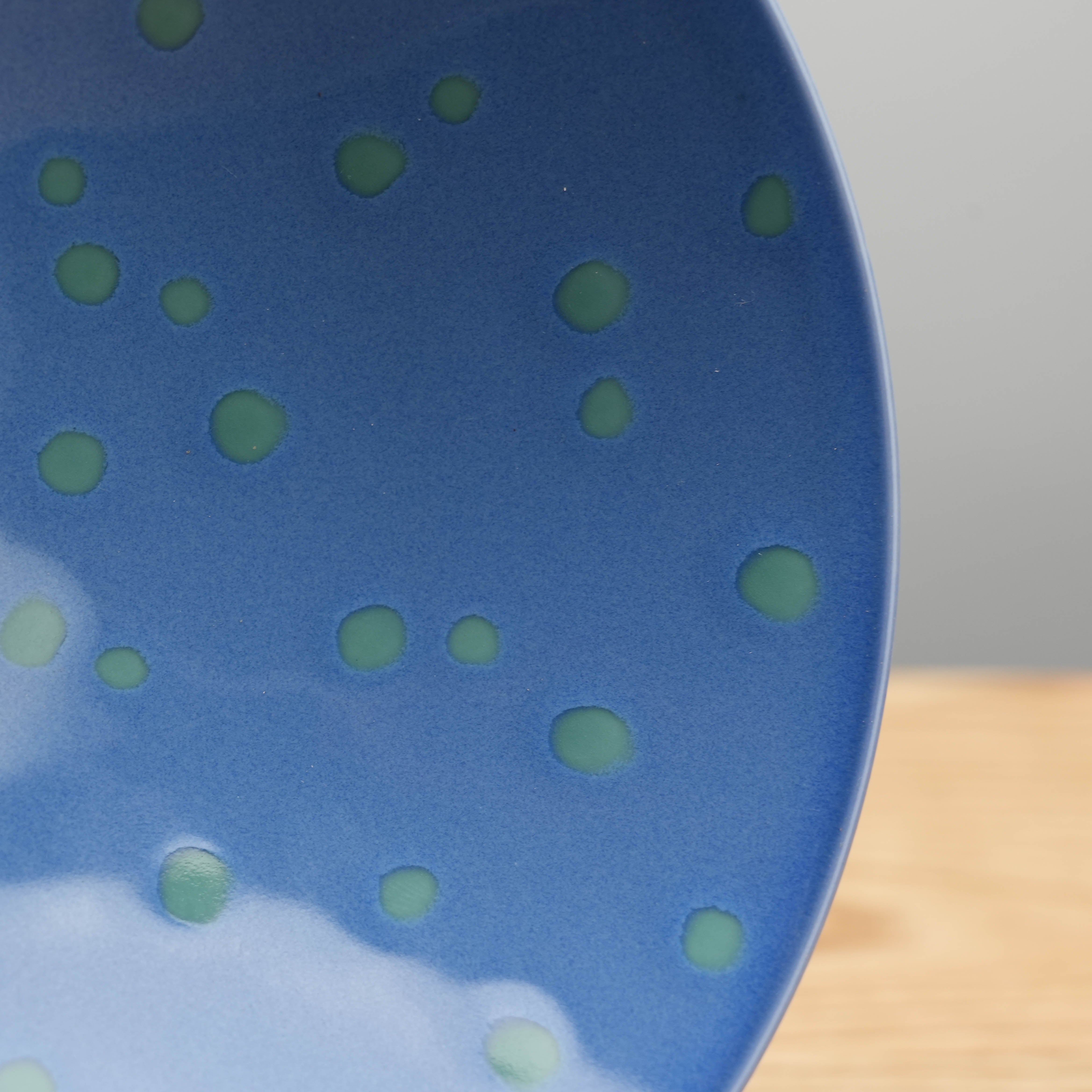 Close-up of Hasami Ware Hakusan Flat Bowl Green Dot showcasing the detailed green dot pattern on the glossy blue ceramic surface.