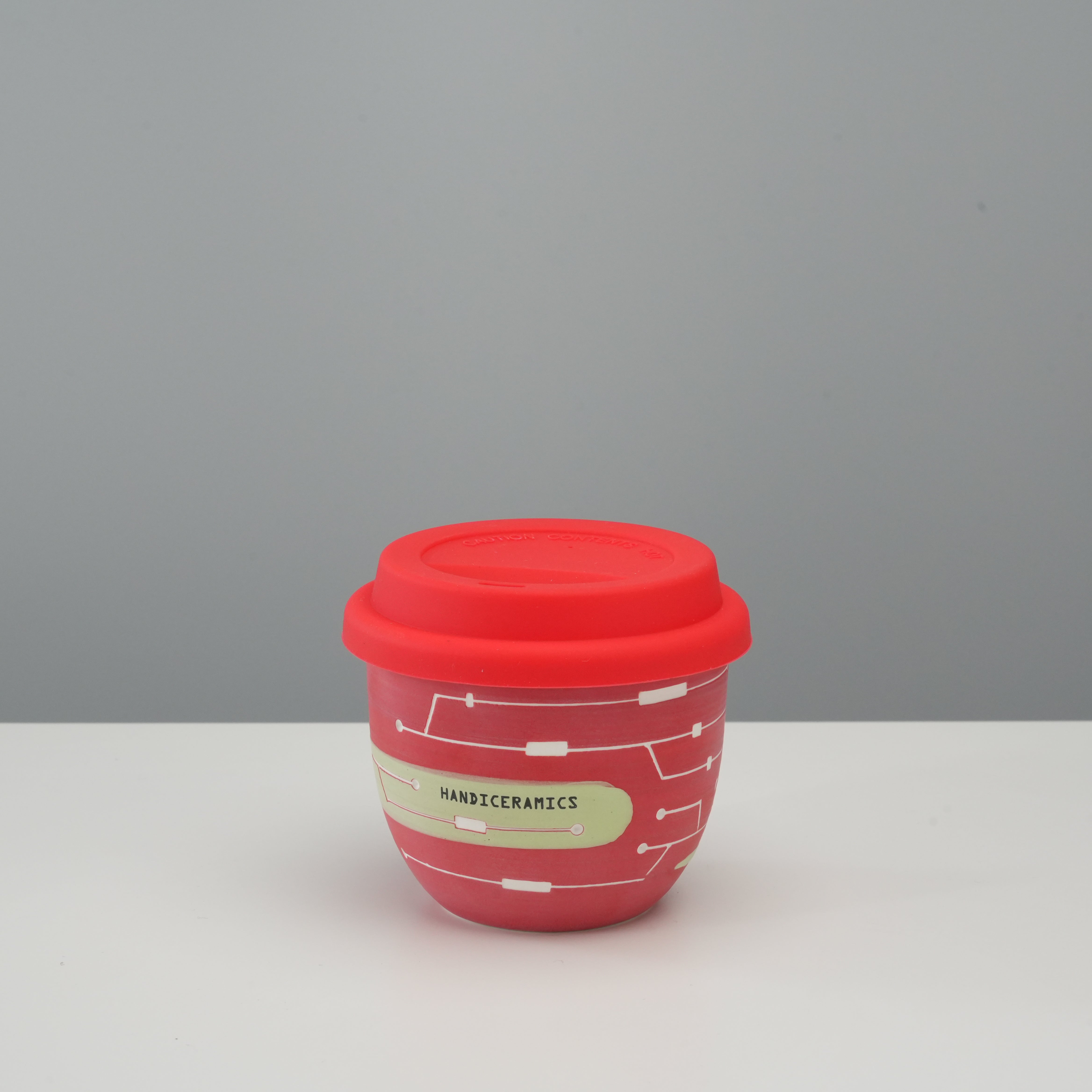Handiceramics Travel Cup - Ceramic Coffee Cup with Lid in Cranberry red, featuring a modern design and silicone lid for spill-free sipping.