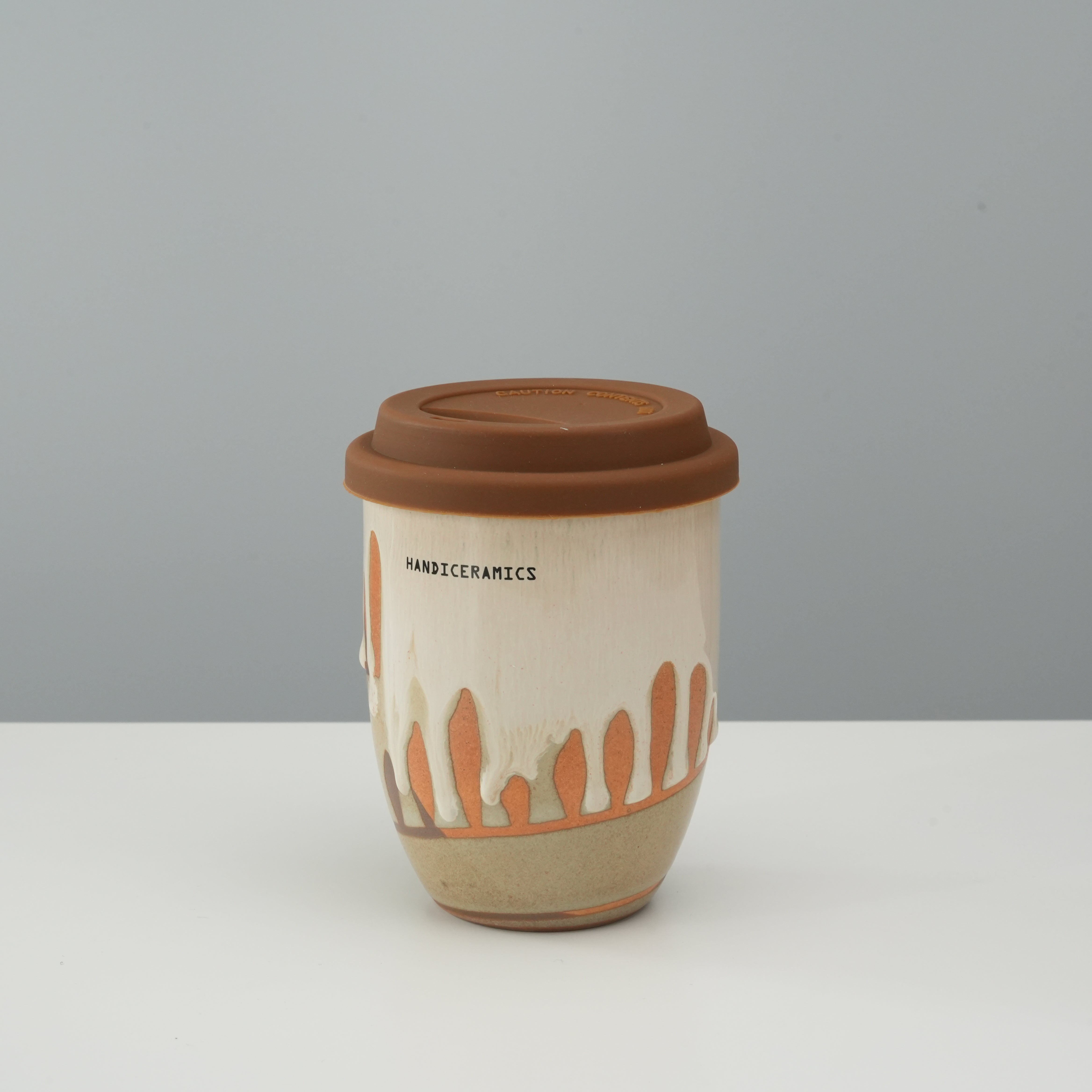 Tall version of Handiceramics Travel Cup with hot chocolate glaze and silicone lid, perfect for stylish and eco-friendly coffee drinking.