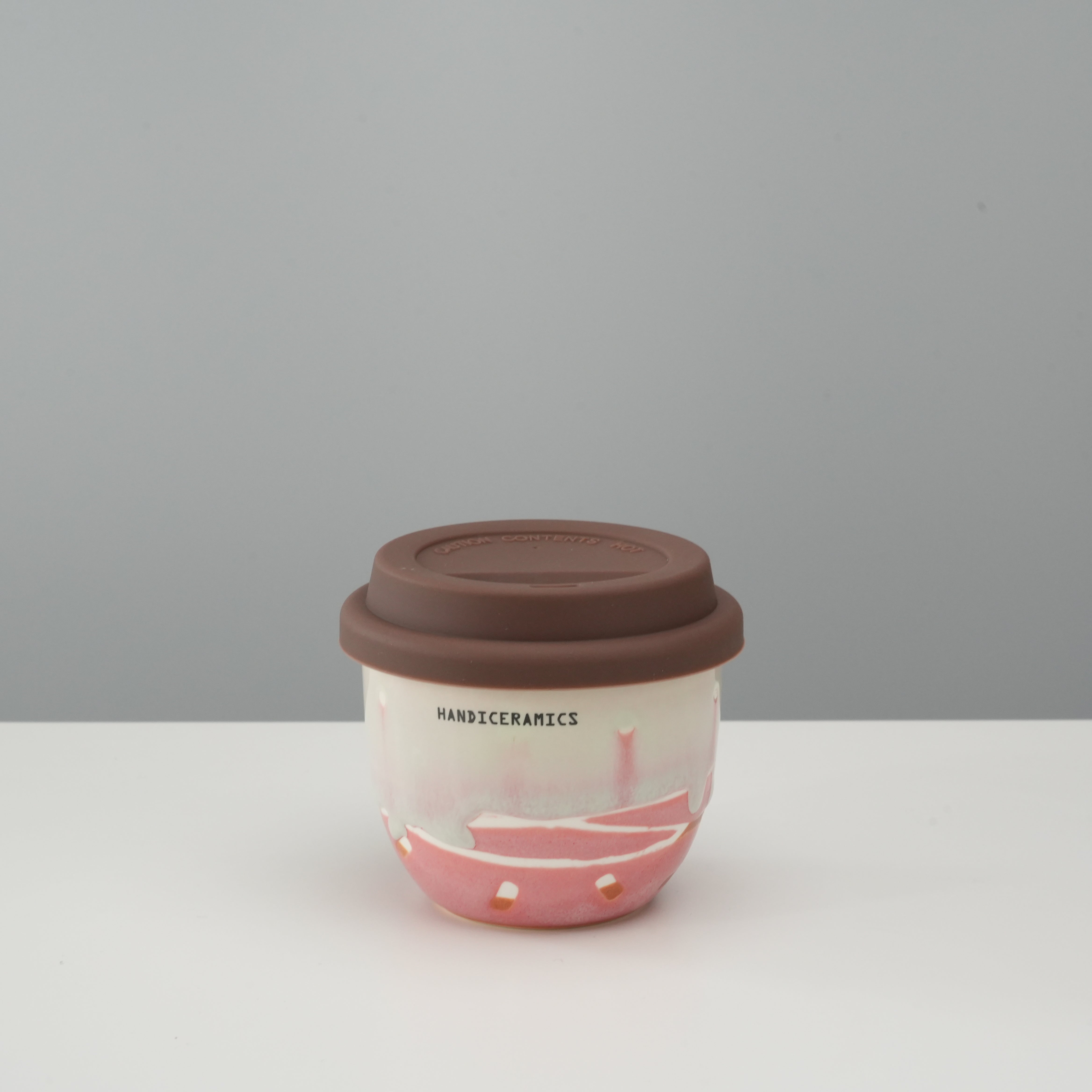 Handiceramics Travel Cup - Ceramic Coffee Cup with Lid in strawberry pink with brown silicone lid, ideal for hot drinks on the go.