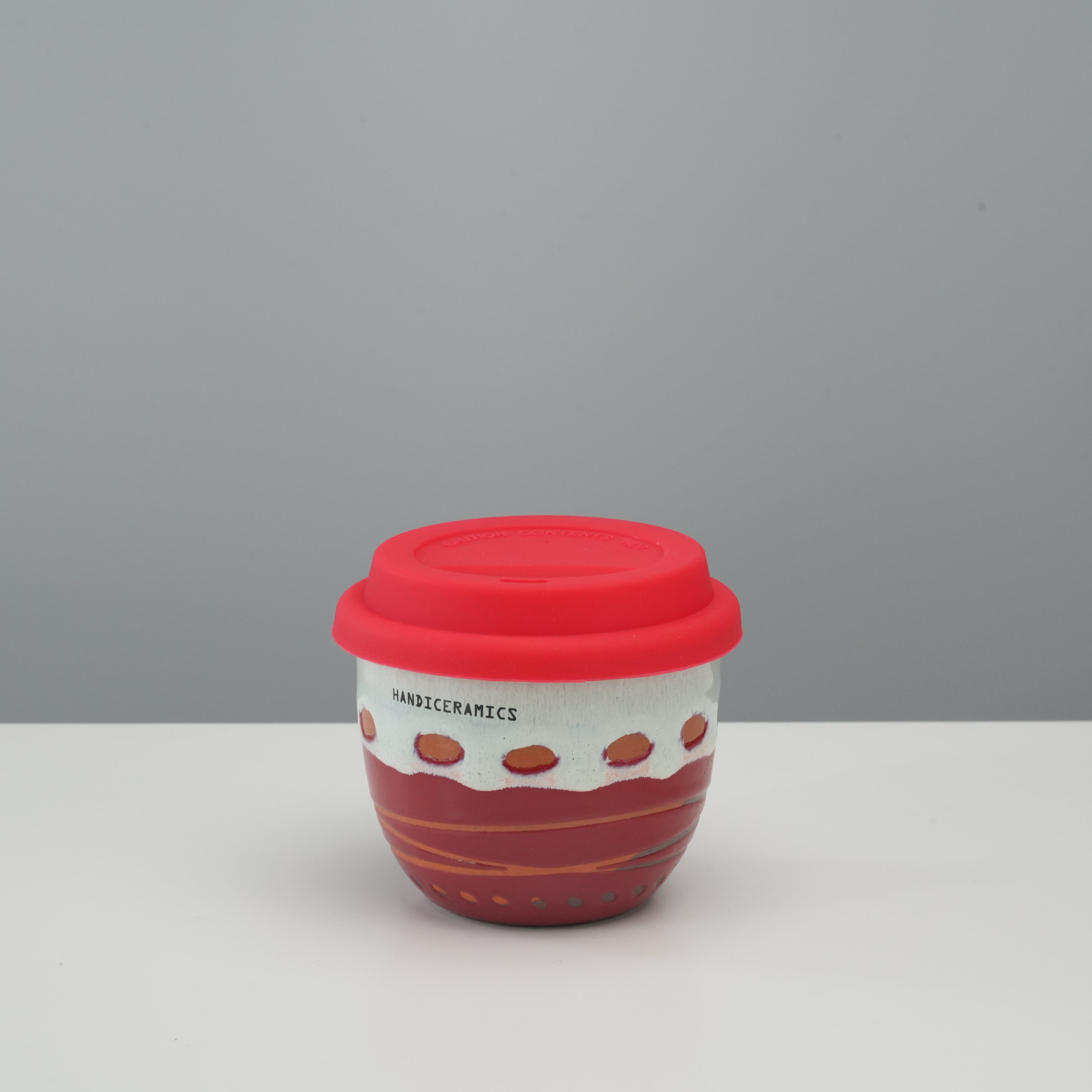 Handiceramics Travel Cup - Ceramic Coffee Cup with Lid in raspberry red, featuring a hand-crafted acorn design and silicone lid for secure sipping.