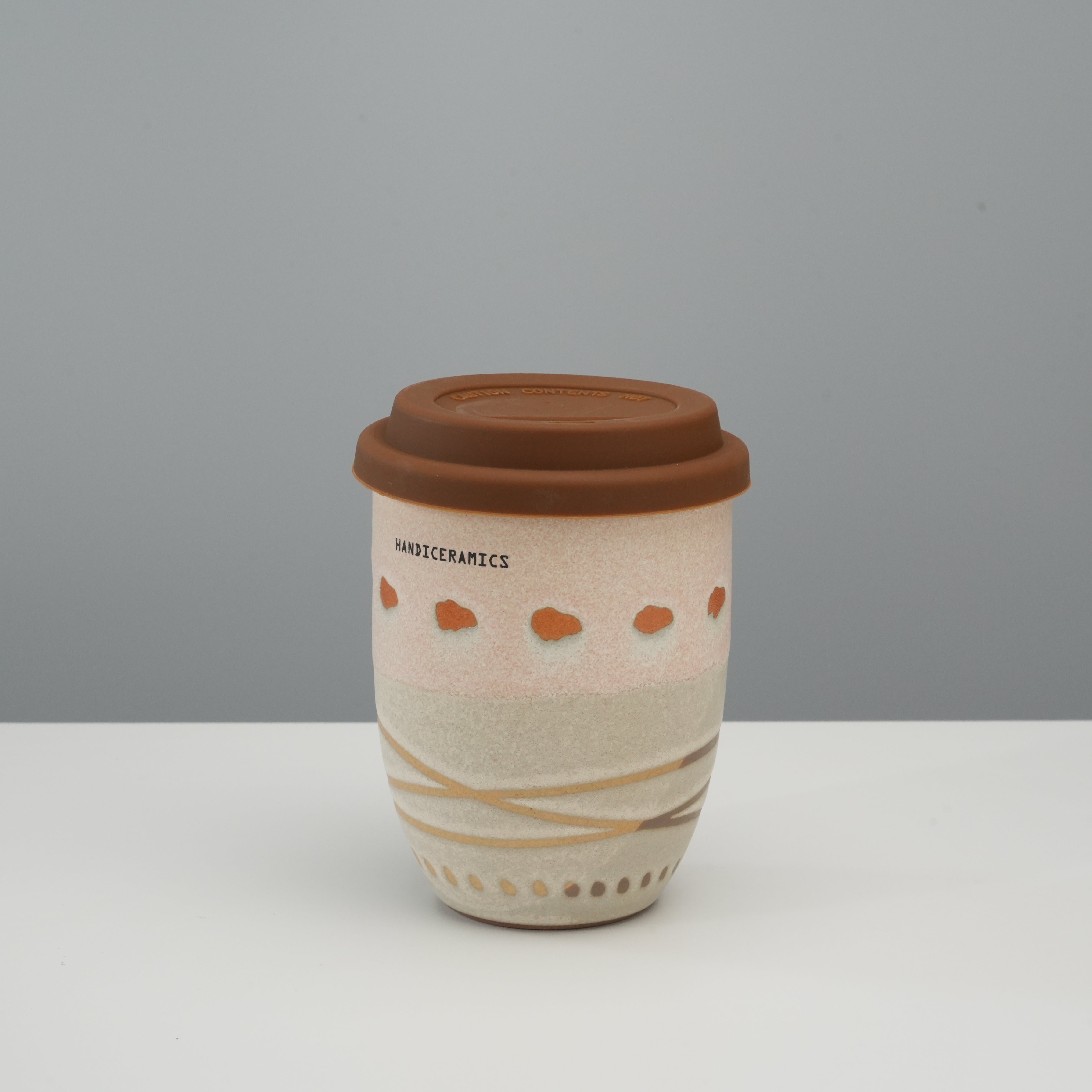 Handiceramics Travel Cup - Ceramic Coffee Cup with Lid in Latte, tall version with pink and beige tones and acorn-inspired pattern.