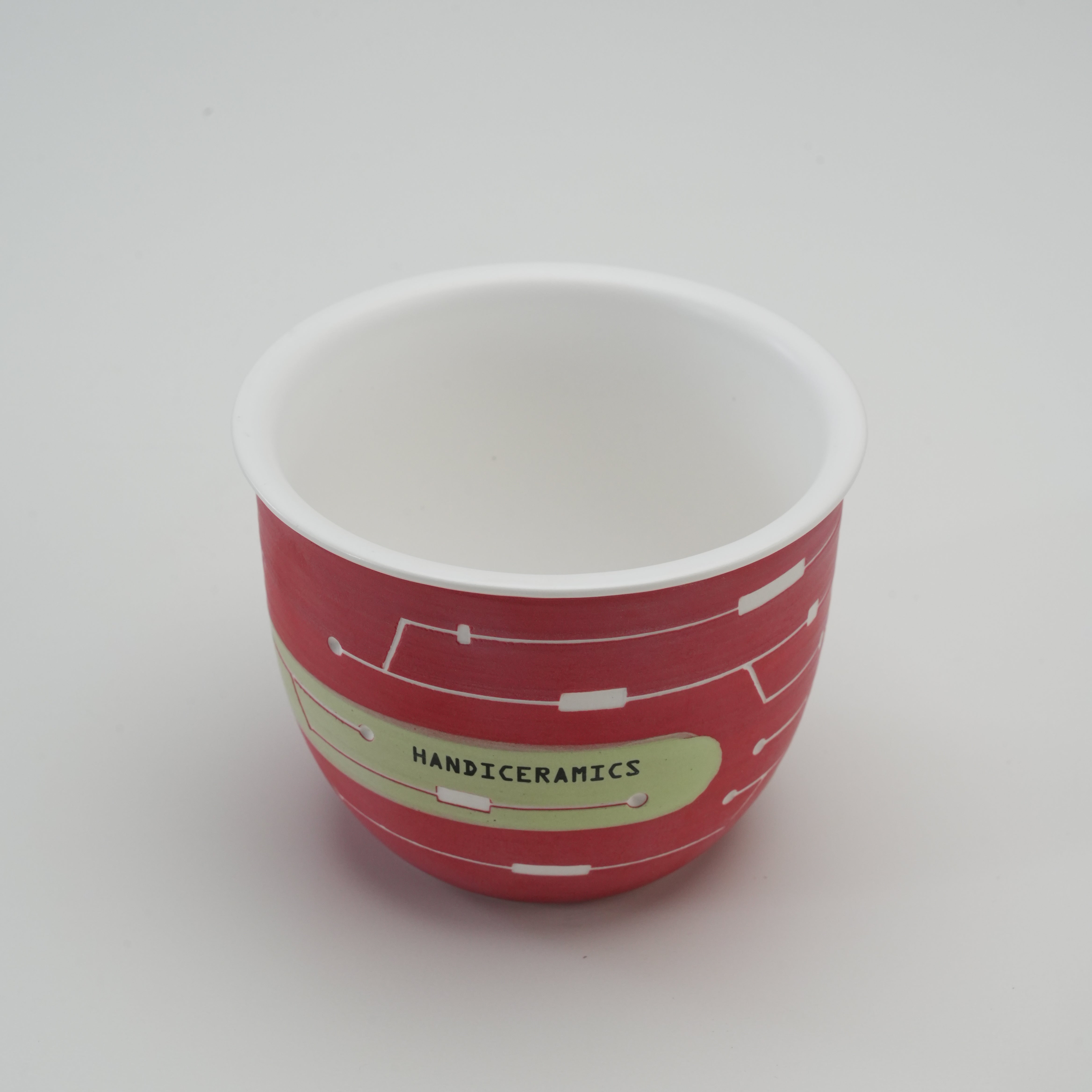 Handiceramics Travel Cup - Ceramic Coffee Cup in Cranberry without lid, showing smooth white interior and hand-painted exterior design.