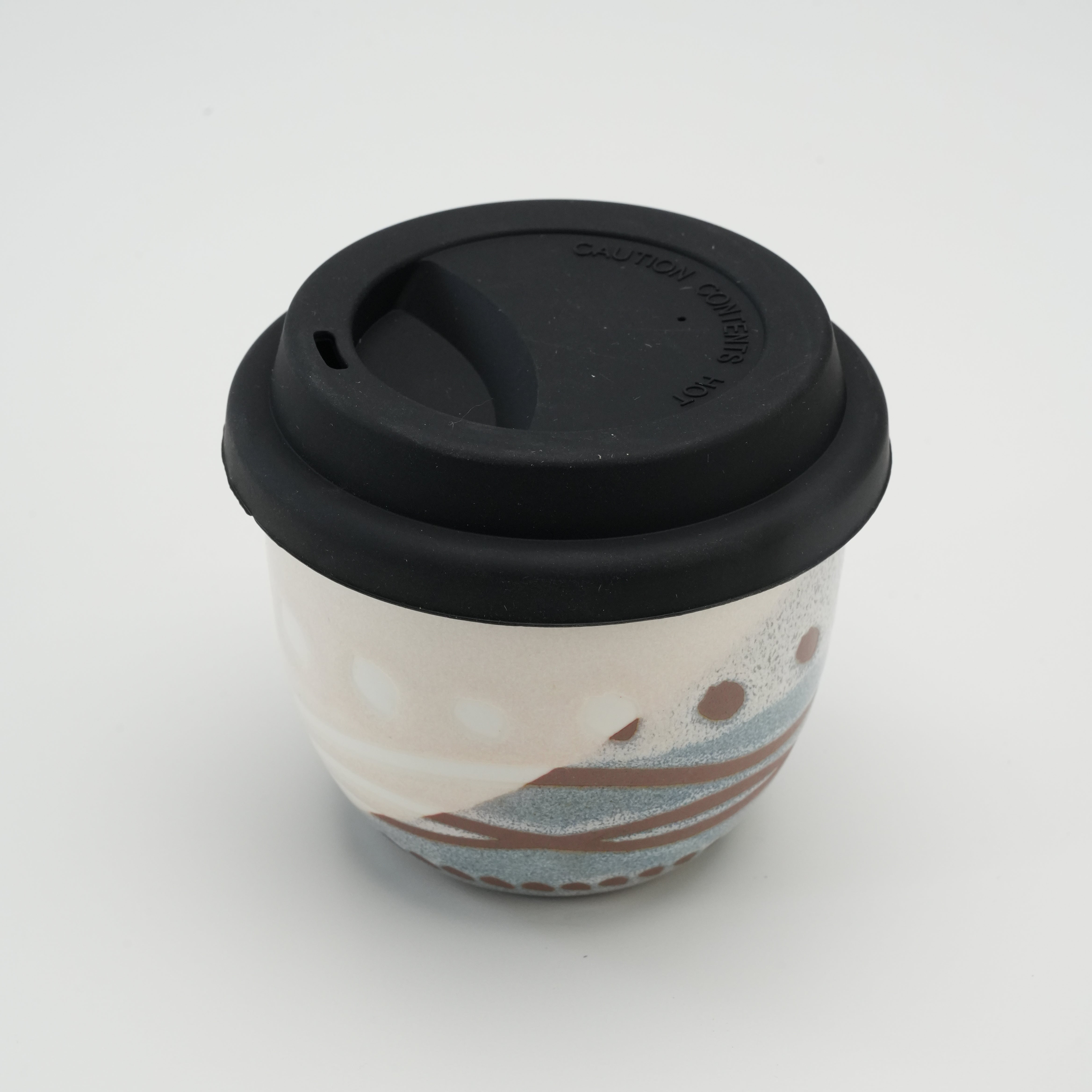 Handiceramics Acorn Travel Cup with black lid, showcasing a handcrafted ceramic body in Marshmallow with dotted and striped design for eco-friendly coffee drinking.
