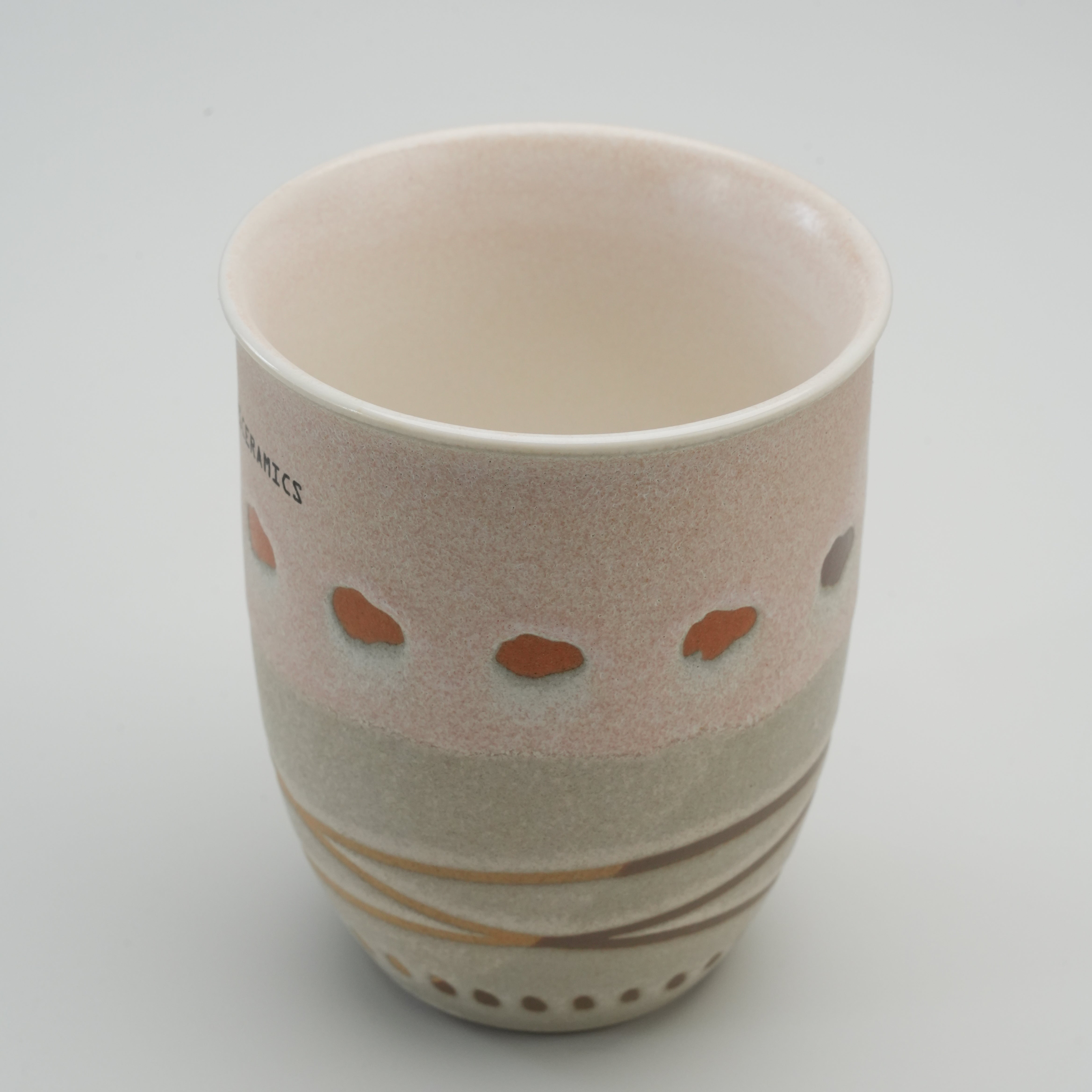 Interior of tall Handiceramics Acorn Travel Cup in Latte, showcasing smooth ceramic glaze and unique artisan design for daily coffee use.