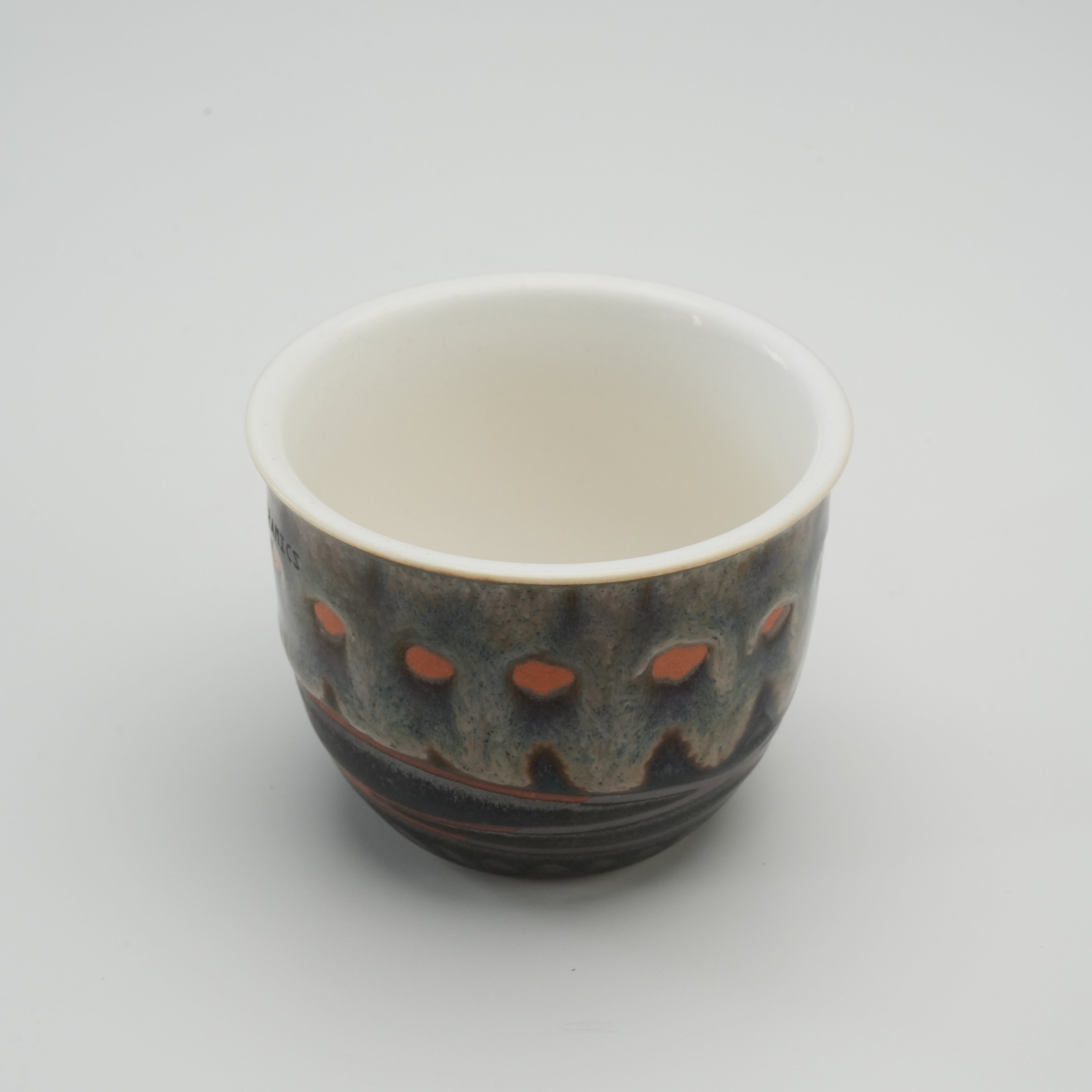 Interior view of Handiceramics Acorn Travel Cup without lid, highlighting smooth white ceramic finish and handcrafted exterior design.