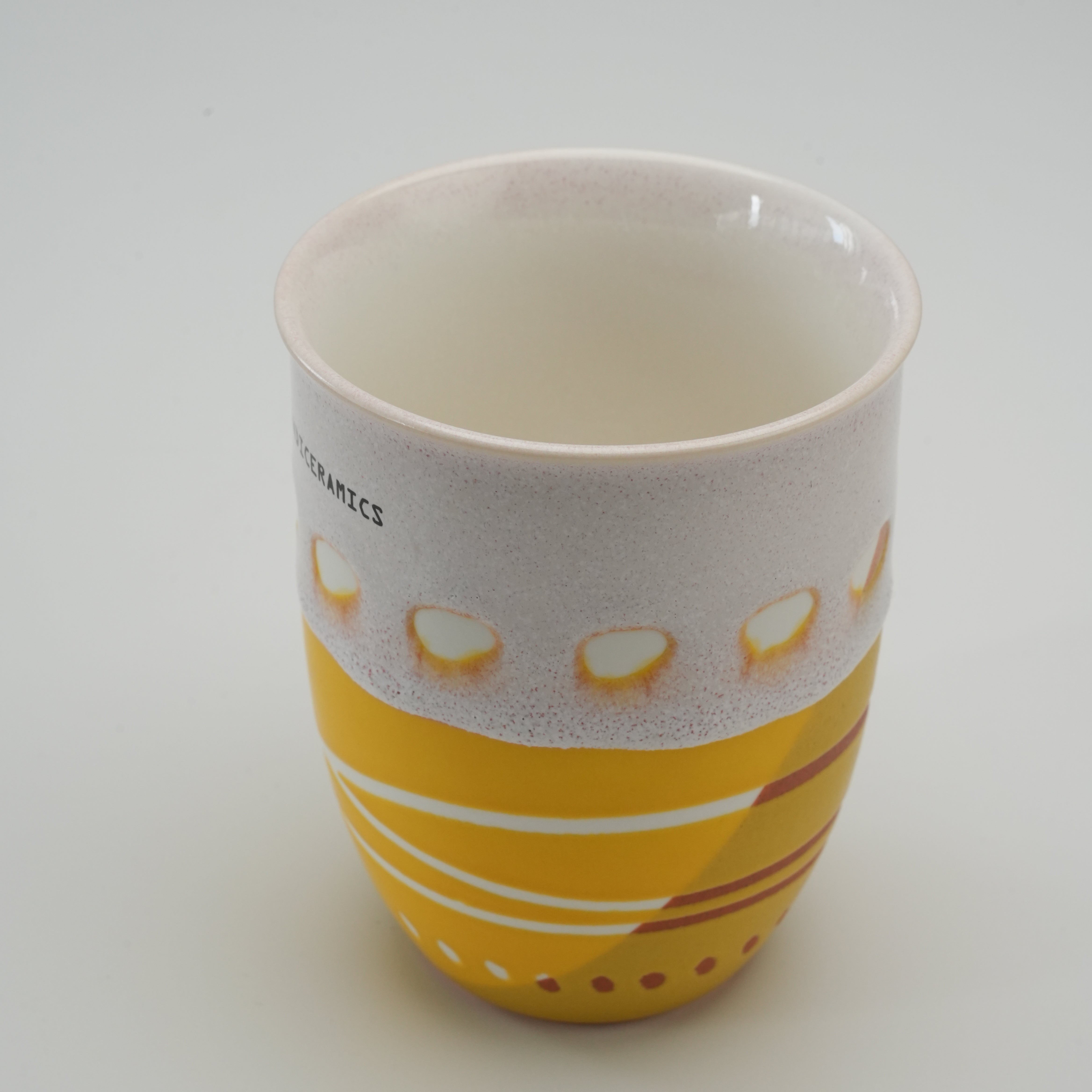 Interior view of Handiceramics Travel Cup in Lemon, displaying the glossy ceramic finish and hand-painted exterior design without the lid.