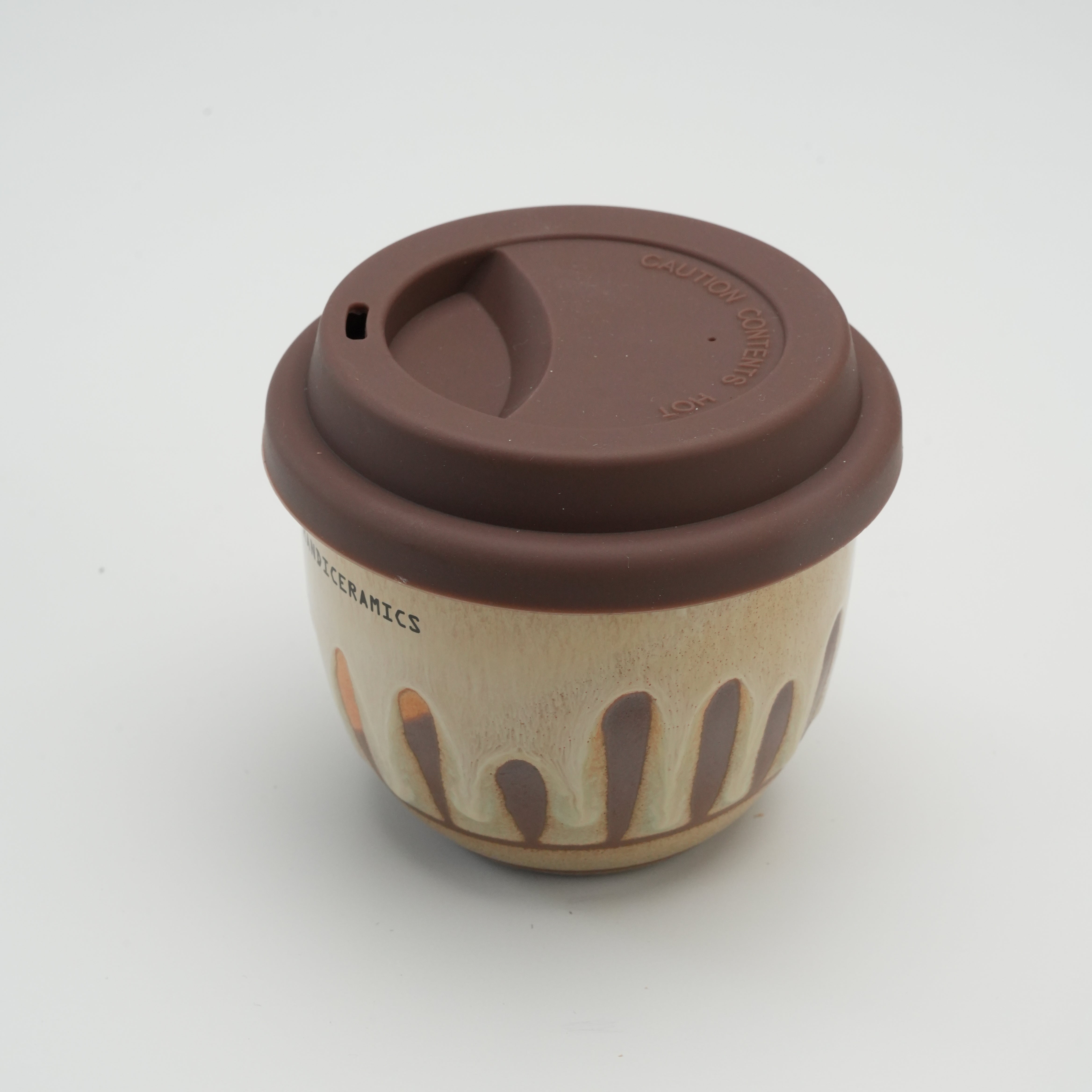 Close-up of Handiceramics Boba Travel Cup with brown silicone lid, showcasing textured ceramic glaze and compact design for hot beverages.