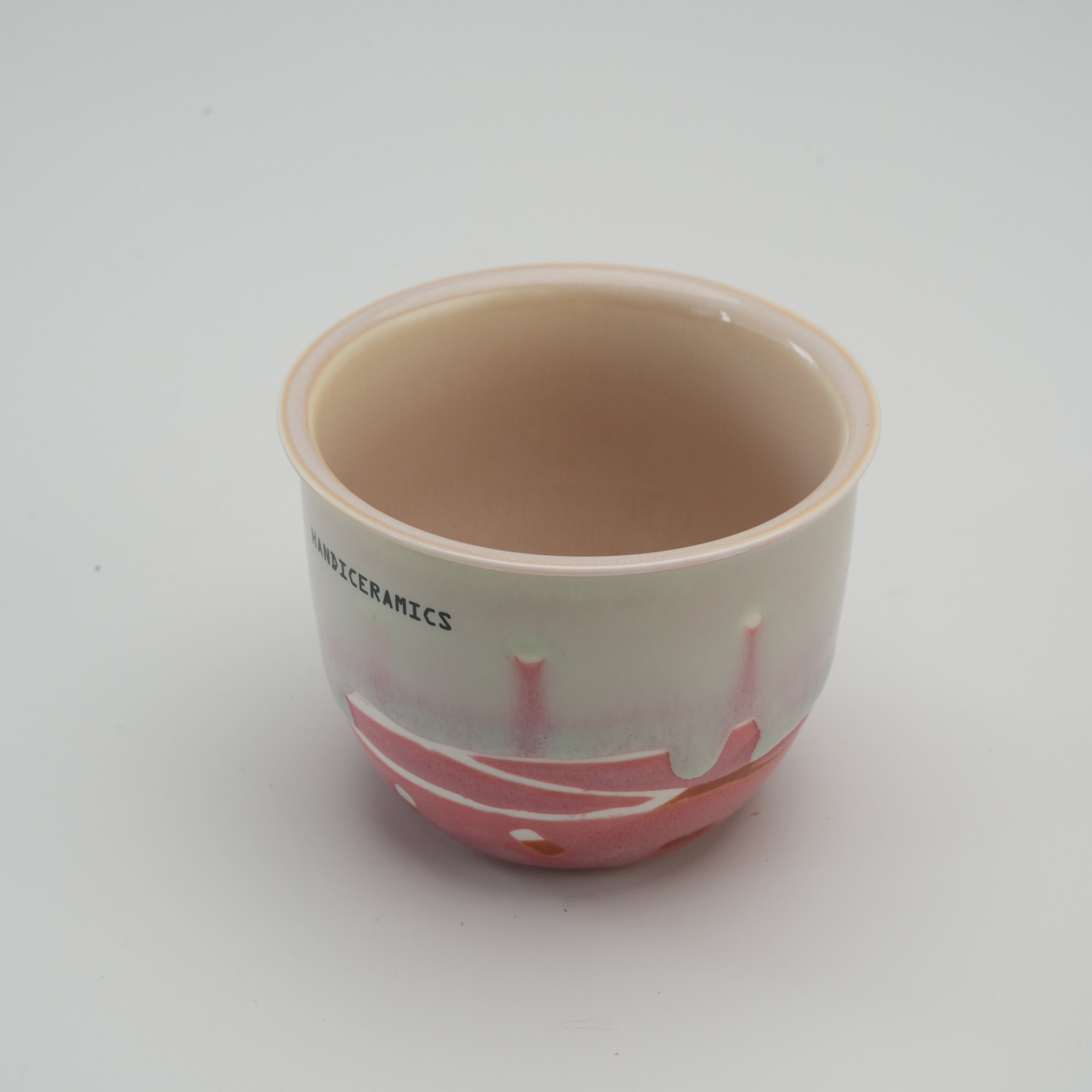 Open Handiceramics Travel Cup in strawberry color without lid, showcasing smooth ceramic interior for easy cleaning and daily use.