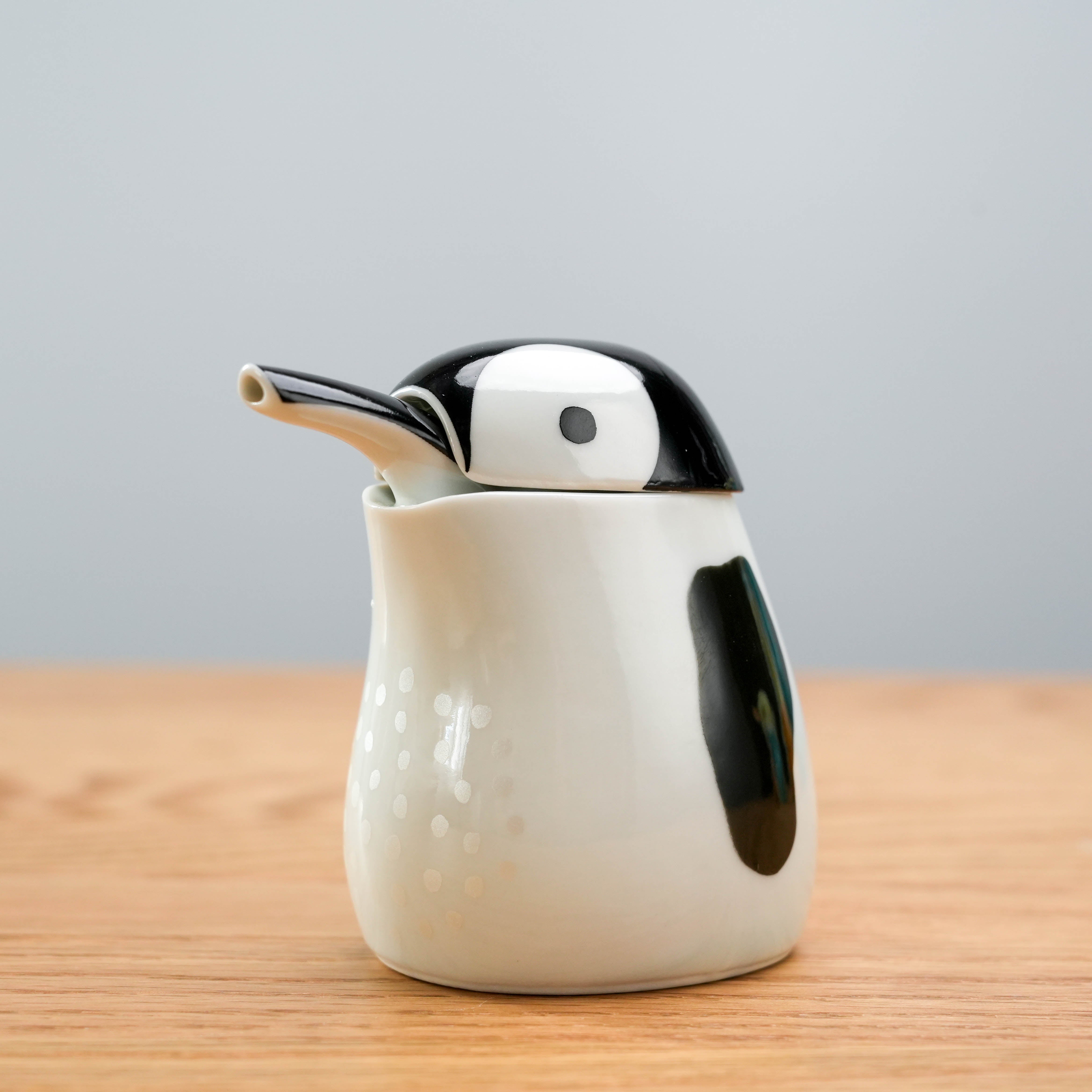 Close-up of the Arita Penguin Soy Sauce Dispenser showing fine ceramic details and glossy black-and-white finish.