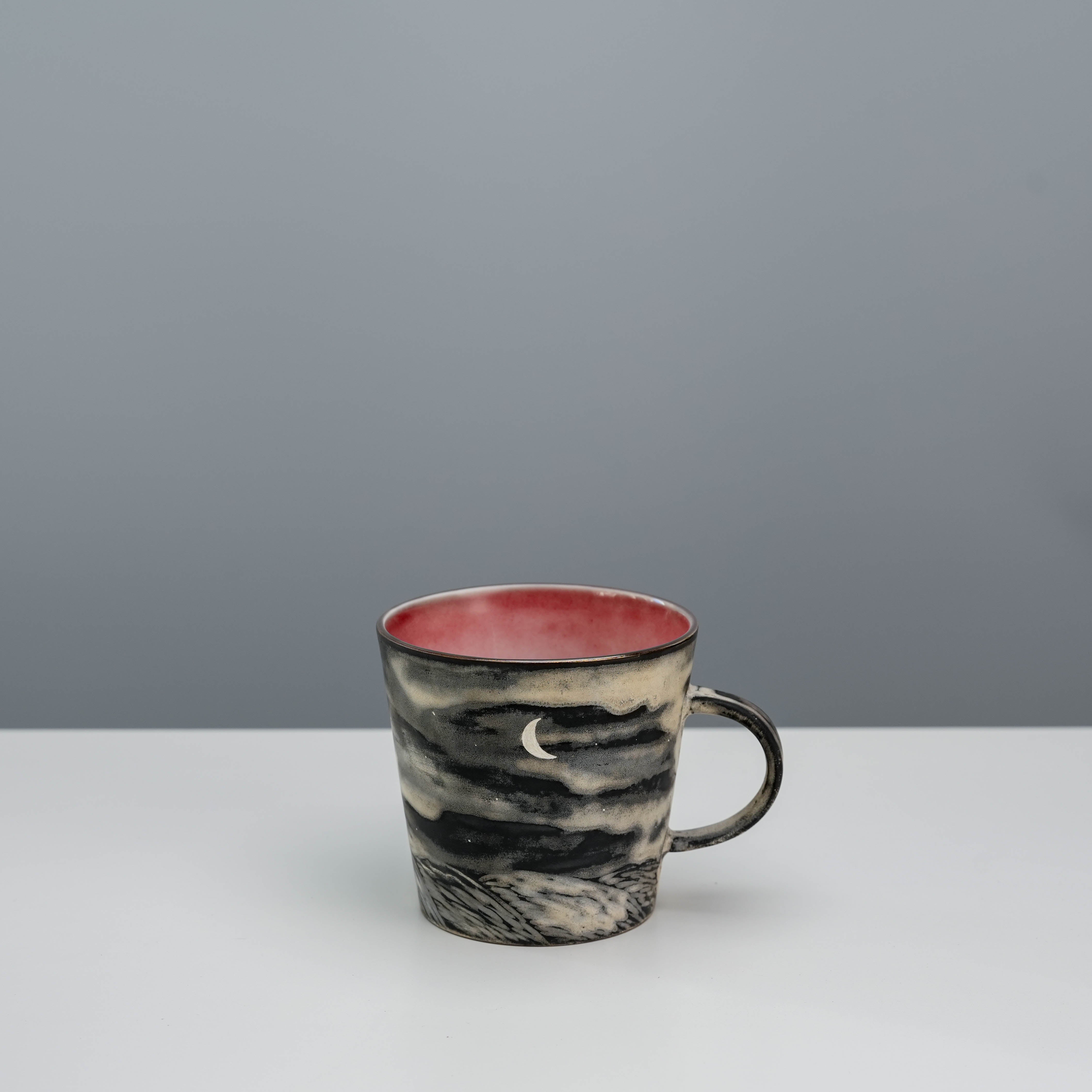 Lonesome Studio Moon Mug with crescent moon design and silver glaze, featuring a red interior and night sky illustration.