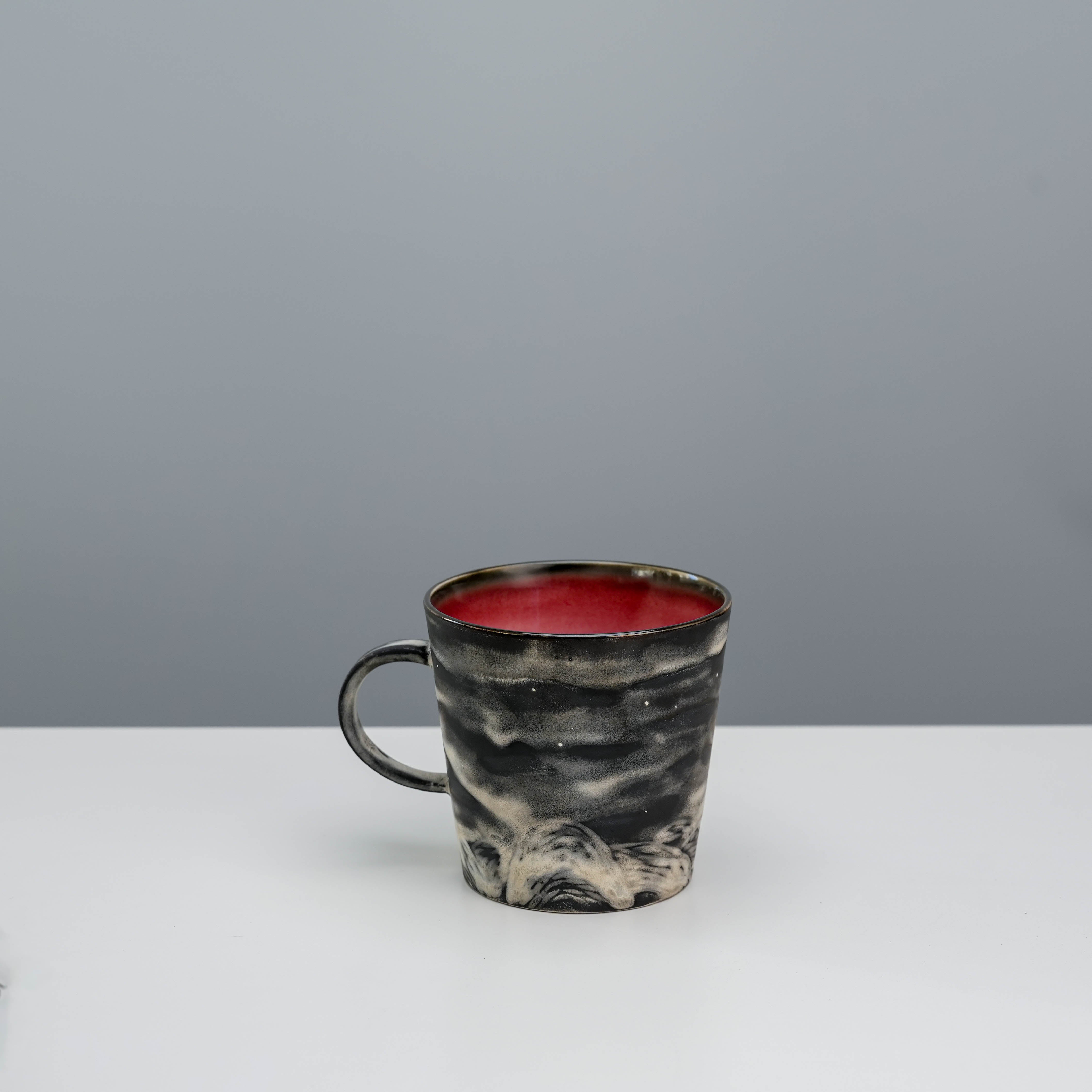 Rear angle of Lonesome Studio Moon Mug showing hand-crafted glaze and textured black-and-white landscape design.