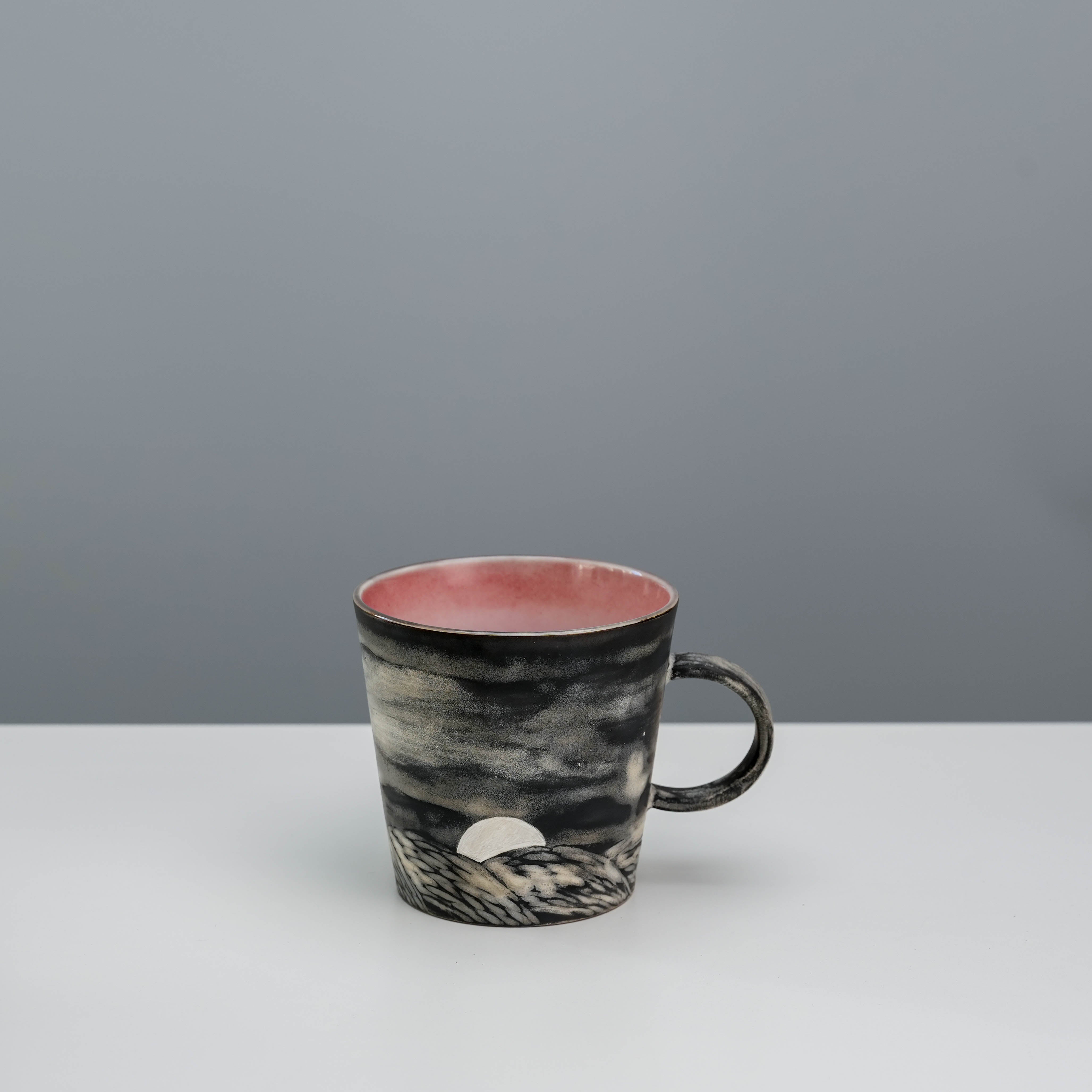 Silver glazed ceramic coffee mug with moonrise scene and red interior, part of the Lonesome Studio Evening Moon Mug collection.