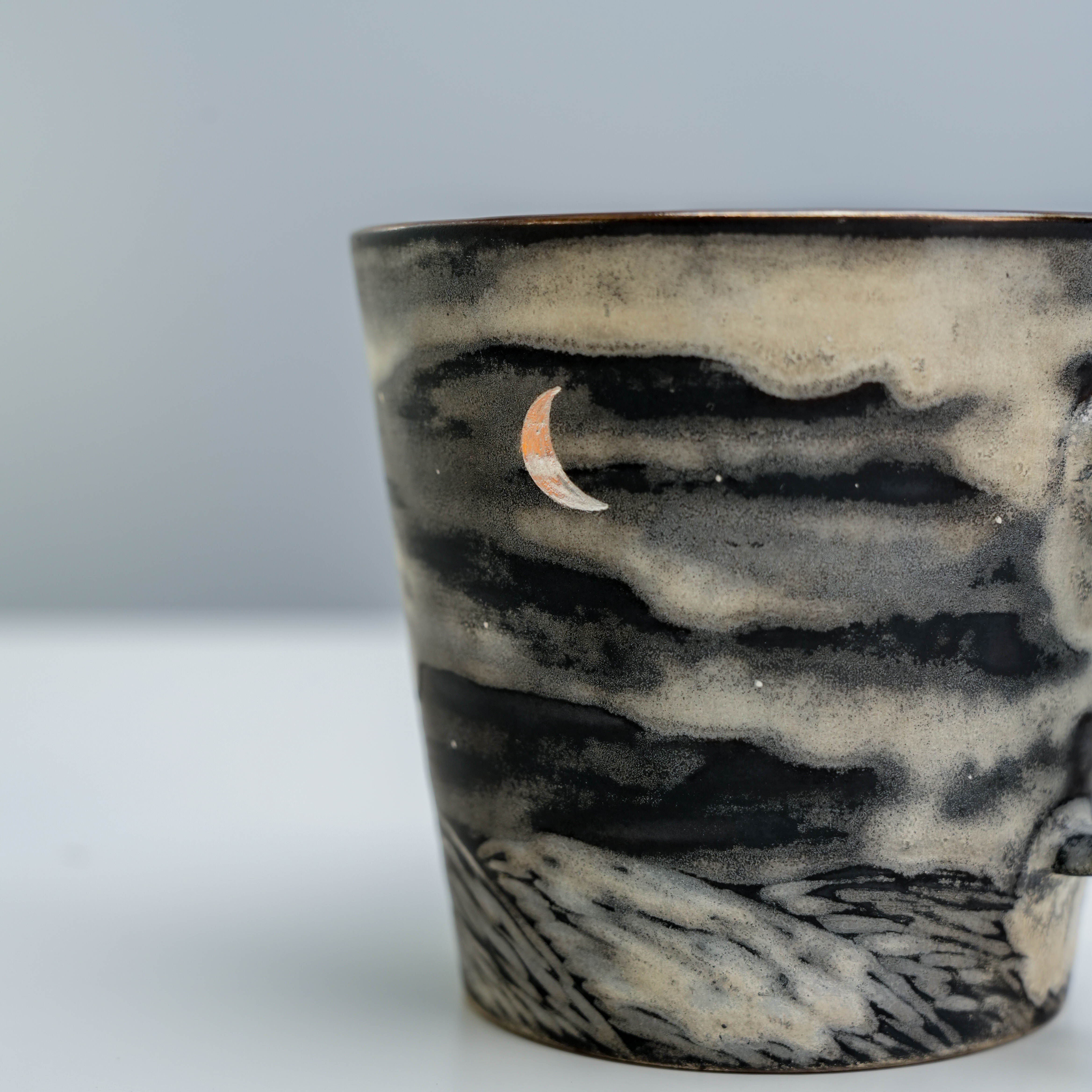 Close-up of Lonesome Studio Moon Mug highlighting crescent moon and silver-glazed cloudy night sky artwork.