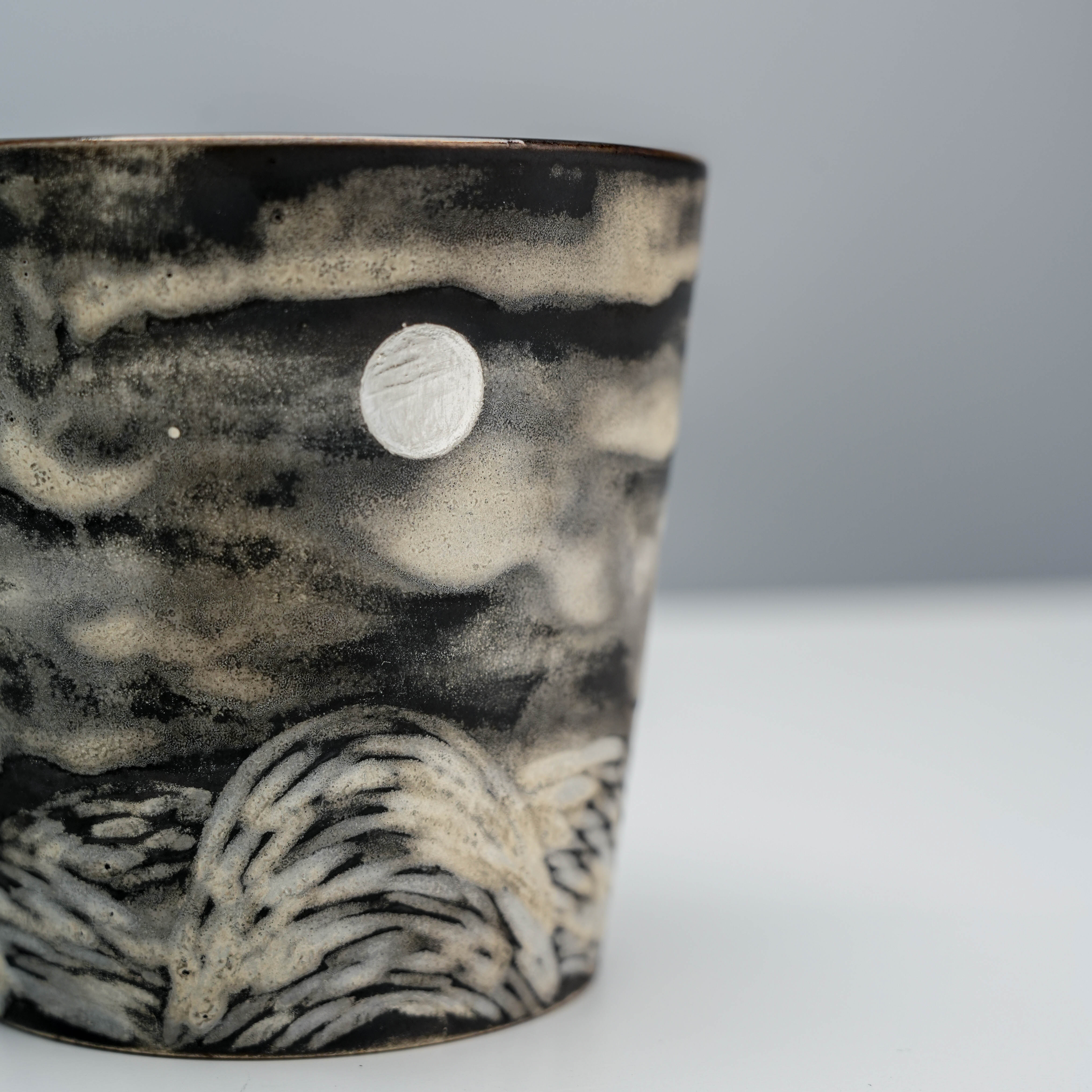 Detail of Full Moon Mug's silver-glazed moon and carved hills, showcasing Lonesome Studio's craftsmanship in artistic drinkware.