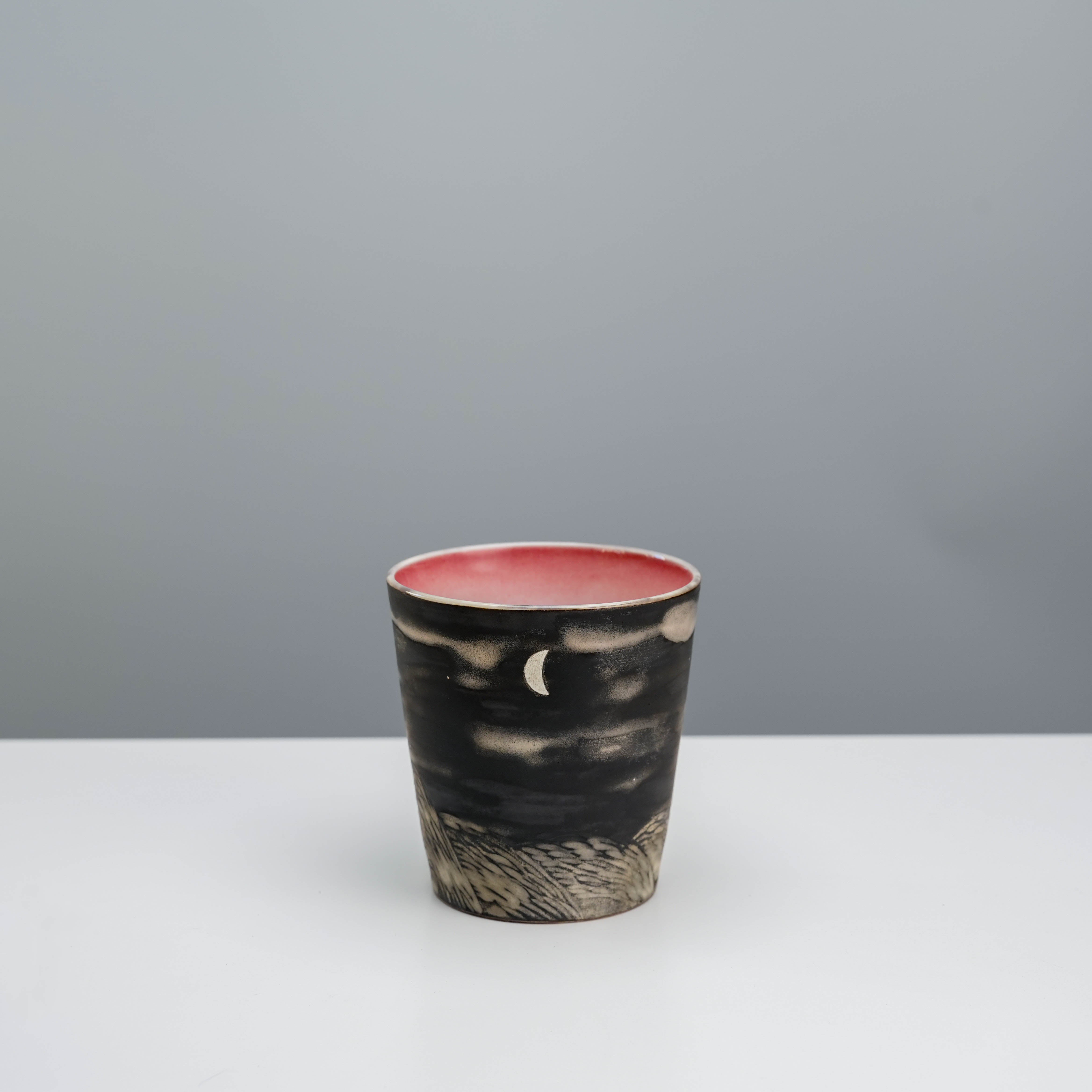 Side view of Lonesome Studio Moon Tumbler featuring a crescent moon and textured landscape, ideal for coffee or tea.
